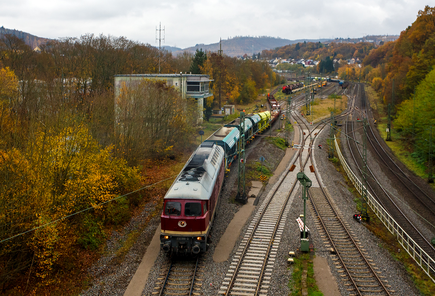 Die „Ludmilla“ in der DR-Farbgebung „bordeauxrot“ 232 088-5 (92 80 1232 088-5 D-SLRS) der SRS - Salzland Rail Service GmbH (Bernburg/Saale) rangiert am 09 November 2025 im Rbf Betzdorf/Sieg einige Schotter- und Res-Wagen. Rechts die zweigleisige Siegstrecke (Köln – Siegen / KBS 460), hinten im Rbf wurde Gleise erneuert und z.Z. wird eins gestopft. Links das Stellwerk Betzdorf Fahrdienstleiter Bf.

Die ex DR V 300 wurde 1974 von LTS (Luhanskyj Teplowosobudiwnyj Sawod auch bekannt als Lokomotivfabrik Lugansk (ehemals Woroschilowgrad)) unter der Fabriknummer 0304 gebaut und als 132 088-6 an die Deutsche Reichsbahn (DR) geliefert.  Zum 01.01.1992 erfolgte die Umzeichnung in DR 232 088-5 und zum 01.01.1994 dann in DB 232 088-5. Die Ausmusterung bei der DB erfolgte zum 30.08.1998. Im August 2002 ging sie an die WAB - Westfälische Almetalbahn GmbH in Altenbeken (als Nr. 30), bis sie im Januar 2004 an die EfW-Verkehrsgesellschaft mbH in Frechen ging. Im Februar 2018 wurde sie dann an die Salzland Rail Service GmbH in Bernburg (Saale) verkauft.

Die Diesellokomotiven der DR Baureihe 130 (DB 230), 131 (DB 231), 132 (DB 232, 233, 234, 241 und 754) und 142 (DB 242) wurden ab 1970 aus der damaligen Sowjetunion in die DDR importiert und bei der Deutschen Reichsbahn für den Personen- und Güterverkehr in Dienst gestellt. Die Baumuster wurden noch als V 300 auf der Leipziger Messe vorgestellt.

Von der Baureihenfamilie wurden zwischen 1970 und 1982 insgesamt 873 Stück in Dienst gestellt. Nach 1990 kam die unter Eisenbahnern ungebräuchliche Bezeichnung „Ludmilla“ auf.

Die Baureihe 132 war universell einsetzbar, sowohl im hochwertigen Schnellverkehr als auch im schweren Güterzugdienst. Nebenstrecken mit weniger als 20 t Achslast konnte die BR 132 nicht befahren.

Die Leistung wird von einem direkteinspritzenden 16-Zylinder-Viertakt-Dieselmotor vom Typ Kolomna 5D49 bereitgestellt. Der Motor liefert mit Turbolader und Ladeluftkühler 2.230 kW (3.000 PS). Der Dieselmotor treibt außer der Licht- und Erregermaschine vor allem einen Drehstromhauptgenerator und einen Drehstromheizgenerator an.

Die Kraftübertragung erfolgt elektrisch. Der Traktionsstrom wird über eine Sechs-Wege-Gleichrichtung von 240 Dioden in Gleichstrom gewandelt. Die Leistungsregelung erfolgt über die Dieselmotordrehzahl und einen Thyristorfeldregler der Erregermaschine.

TECHNISCHE DATEN der BR 232:
Hersteller: 	Lokomotivfabrik Woroschilowgrad (heute Luhansk)
Spurweite: 	1.435 mm (Normalspur)
Achsformel: Co’Co’
Länge über Puffer: 20.820 mm
Breite des Lokkastens: 2.950 mm
Höhe über Schienenoberkannte: 4.590 über SOK
Drehzapfenabstand: 11.980 mm
Achsstand im Drehgestell: 2 x 1.850 mm (3.700 mm)
Treibraddurchmesser: 	1.050 mm (neu) / 952 mm (abgefahren)
Dienstgewicht: 124 t
Radsatzfahrmasse:  20,4 t 
Motorbauart: direkteinspritzenden V-16-Zylinder-Viertakt-Dieselmotor mit Abgasturbolader und Ladeluftkühlung, 4 Ventile pro Zylinder, mit Zylindergruppenabschaltung
Motorentyp: Kolomna 5 D 49 /16 Tsch N 26/26
Motorhubraum: 220,9 l
Ladeluftdruck: 1,3 bar
Einspritzbeginndruck: 320 bar
Max. Verbrennungsdruck: 115 bar
Motorleistung: 2.230 kW (3.000 PS)
Leistungsübertragung: elektrisch
Anfahrzugkraft: 294 kN
Dauerzugkraft: 194 kN
Höchstgeschwindigkeit: 120 km/h
Tankinhalt: max. 6.000 l
