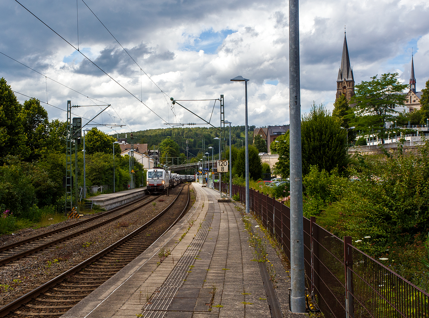 Die „wei�e“ an die TX Logistik AG (Bad Honnef) vermietete SIEMENS Vectron MS 193 597  I do the Job of 40 Trucks  (91 80 6193 597-2 D-ATLU) der Alpha Trains Luxembourg s.�.r.l. (Luxembourg) f�hrt am 14 Juli 2024, mit einem langen mit Nutzfahrzeuge (FIAT - Kastenwagen) beladenen Flachwagenzug (2 x 2 achsige Flachwageneinheiten), durch Kirchen (Sieg) in Richtung K�ln.

Nochmals einen lieben Gru� an den netten Lokf�hrer zur�ck.

Die Siemens Vectron MS wurde 2020 von Siemens Mobility GmbH in M�nchen-Allach unter der Fabriknummer 22865 gebaut und war erst als 91 80 6193 597-2 D-SIEAG der Siemens Mobility GmbH zugelassen. Im Jahr 2021 wurde sie an die Alpha Trains Belgium NV/SA in Antwerpen verkauft und ab Juni 2021 an die TX Logistik AG vermietet. 
