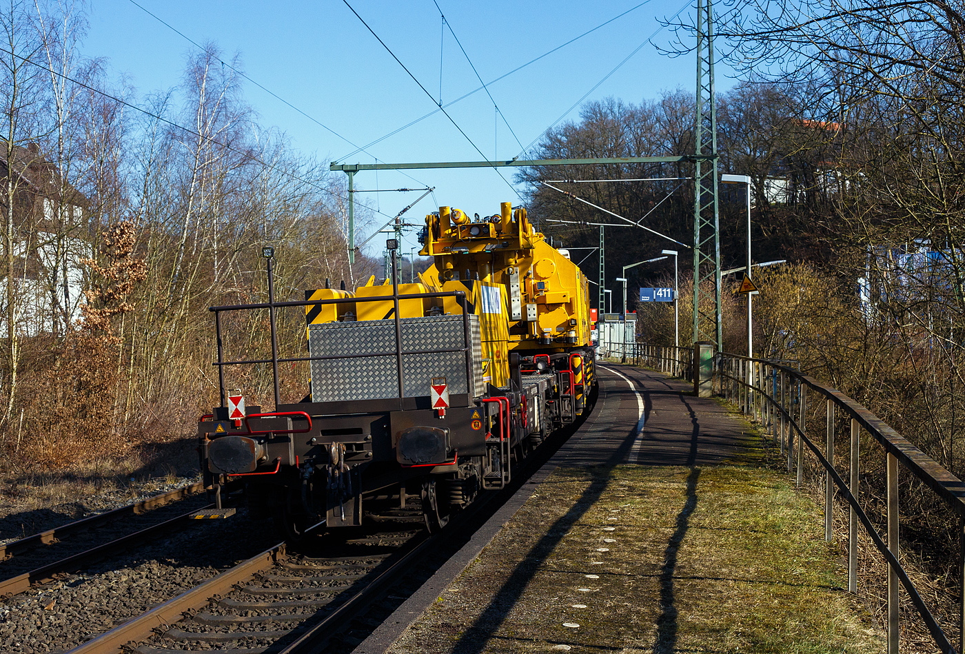 Die an die BEG - Bocholter Eisenbahngesellschaft mbH vermietete 4185 132-2 „Christa“ (92 80 4185 132-2 D-NXRL), eine Vossloh DE 18 der Nexrail AssetCo Sàrl (Luxembourg) fährt am 17 Februar 2025, mit dem Kirow KRC 1200 Kranzug der MGW Gleis- und Weichenbau-GmbH & Co.KG (Berlin), durch Scheuerfeld/Sieg in Richtung Siegen. Hinter der Lok sind der Schutzwagen D-MGWB 37 80 3999 232-4, der KRC 1200 Kranwagen D-MGWB 99 80 9519 003-4 und der Gegenlastwagen D-MGWB 99 80 9310 031-6.

Hier am Zugschluss, hinter dem Multi Tasker Kran KRC 1200, der zugehörige 4-achsiger Gegenlastwagen D-MGWB 99 80 9310 031-6, beladen mit dem Gegengewicht des Krans zudem wird hier in der Transportstellung das Gegengewicht-Teleskop Kranausleger hydraulisch auf dem Gegenlastwagen abgestützt. Durch die Abstützung wird die Achslast und folglich die Streckenlast (Meterlast) vom Kran auf max. 7,2 t/m reduziert. Die max. Achslasten betragen beim Kran 13,7 t und den Wagen 19,9 t.

TECHNISCHE DATEN:
Baujahr: 2022
Spurweite: 1.435 mm
Anzahl der Achsen: 4 (in 2 Drehgesten)
Länge über Puffer: 12.840 mm
Drehzapfenabstand: 8.000 mm
Eigengewicht: 18.800 kg
Maximale Nutzlast: 61,0 t (ab Streckenklasse C)
Höchstgeschwindigkeit: 100 km/h 
Zugelassen für Streckenklasse: CE oder höher
Bremse: KE-GP-A (K)
Handbremse: Ja
Kleinster befahrbarer Gleisbogen: R = 80m