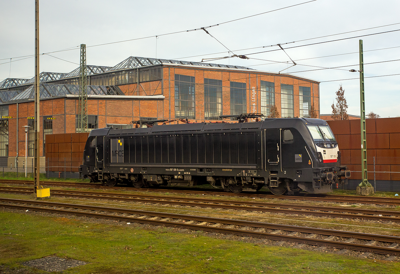 Die an die DB Cargo vermietete MRCE Dispolok 187 108-6 (91 80 6187 108-6 D-DISPO) ist am 14 M�rz 2024 beim Bahnhof Lingen (Ems) abgestellt.

Die Bombardier TRAXX F140 AC3 wurde 2015 von der Bombardier Transportation GmbH in Kassel unter der Fabriknummer 35227 gebaut. Sie war urspr�nglich in DB verkehrsrot und von Bombardier als Vorf�hr- und Mietlok als 91 80 6187 108-6 D-BTK an die DB Cargo vermietet, von 2017 bis 2021 als 91 80 6187 108-6 D-DB eingestellt, wurde sie 2021 an die Mitsui Rail Capital Europe GmbH (MRCE Dispolok) in M�nchen verkauft und erhielt die Neulackierung in MRCE schwarz, ist aber weiterhin an die DB Cargo vermietet. Die TRAXX F140 AC3 in der Varianten BR 187.1 hat keine Last-Mile-Einrichtung. Die H�chstgeschwindigkeit betr�gt 140km/h, sie hat die Zulassung nur f�r Deutschland. Die Lokomotiven k�nnen in gemischter Mehrfachtraktion mit BR185 und BR186 eingesetzt werden
