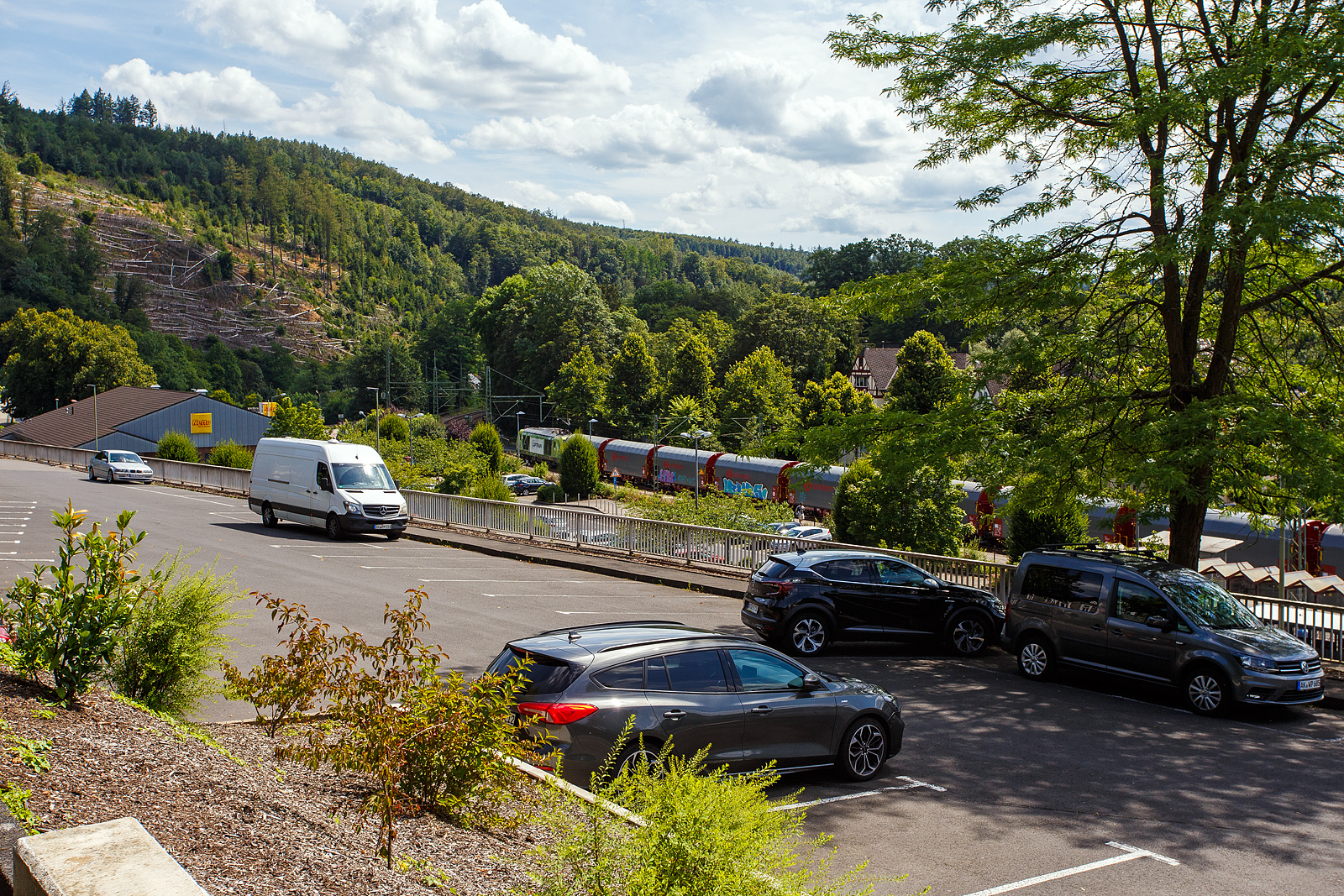 Die an die Dortmunder Eisenbahn GmbH (DE) vermietete SIEMENS Vectron Dual Mode 248 034-1  Phoenix  (90 80 2248 034-1 D-DE) der Captrain Deutschland GmbH fährt am 18 Juli 2024, mit einem Coilzug (Wagen der Gattung Shimmnis-ttu der Ermewa) durch den Bahnhof Kirchen/Sieg in Richtung Köln. 

Die SIEMENS Vectron DM wurde 2022 von Siemens Mobility GmbH in München-Allach unter der Fabriknummer 23185 gebaut und im Februar 2023 an die Captrain ausgeliefert. Die Lok hat die Zulassung für Deutschland und eine Höchstgeschwindigkeit von 160 km/h. Die Hybridlok (Vectron Dual Mode) kann die Antriebsenergie aus der Fahrleitung beziehen (2.400 kW Leistungen am Rad), oder mittels eines MTU 16V 4000 R84 V16-Zylinder-Dieselmotors (2.400 kW Motorleistung, 2.000 kW Leistungen am Rad) erzeugen. 

Die Dortmunder Eisenbahn GmbH (DE) ist eine private Eisenbahngesellschaft aus Dortmund. Die Dortmunder Eisenbahn GmbH ist ein gemeinsames Tochterunternehmen der Dortmunder Hafen GmbH und der Captrain Deutschland GmbH. Sie ist zu 65 Prozent im Besitz der Captrain Deutschland GmbH (deutsche Tochter der SNCF) und 35 Prozent der Anteile hält die Dortmunder Hafen AG. Die DE Infrastruktur GmbH,  mit ca. 50 Kilometern Gleislänge, gehört zu 81 Prozent der Dortmunder Hafen AG und zu 19 Prozent der Captrain Deutschland GmbH.