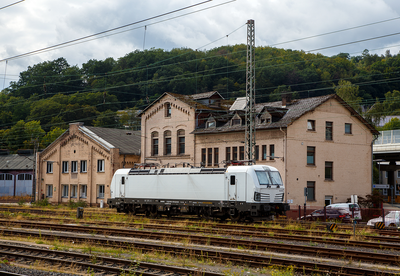 Die an die SETG - Salzburger Eisenbahn TransportLogistik GmbH vermietete weiße SIEMENS Vectron AC DPM 193 919 (91 80 6193 919-8 D-ELOC) der ELL - European Locomotive Leasing ist am 28.08.2023 beim Hbf Siegen abgestellt.

Die SIEMENS Vectron AC DPM mit Diesel Power Modul  bzw. mit LM (Last Mile Diesel) wurde 2022 von Siemens Mobilitiy in München-Allach unter der Fabriknummer 22968 gebaut. Diese Vectron Lokomotive ist als AC DPM – Lokomotive (Wechselstrom-Variante mit Dieselmodul für Rangieren ohne Fahrdraht) mit 6.400 kW konzipiert und zugelassen für Deutschland, Österreich, Bulgarien, Slowakei, Rumänien, Tschechien und Ungarn (D/A/BG/SK/RO/CZ/H), im Dieselbetrieb beträgt die Leistung lediglich 180 kW (160 kW am Rad). 

Diese topmodernen Lokomotiven weisen eine Leistung von 6.400 kW (8.700 PS) auf. Das eingebaute Diesel-Power-Modul ermöglicht das Rangieren ohne Fahrdraht. Zusätzlich sind die Vectron-Lokomotiven von Siemens mit einer Funkfernsteuerung und einer halbautomatischen Bremsprobe ausgerüstet. 

Die Entwicklung der Siemens Lokomotive Vectron basiert auf den Erfahrungen der erfolgreichen EuroSprinter beziehungsweise deren Weiterentwicklung Siemens ES 2007 (NMBS/SNCB-Reihe 18/19) ersetzt. Ausgereifte und bewährte Technik ist mit Flexibilität und Modularität kombiniert. Die Vectron Lokomotive ist für die vielfältigsten Verkehrsaufgaben konzipiert. Ob im nationalen oder grenzüberschreitenden Verkehr, ob im Personen- oder Güterverkehr. Es werden vier elektrische Versionen und eine dieselelektrische Version der Lokomotivplattform angeboten. Die hier gezeigten Vectron Lokomotiven sind als AC – Lokomotiven (Wechselstromlok) mit 6.400 kW Leistung) konzipiert und haben ein Diesel Power Modules (DPM) / Rangiermodul bzw. Last Mile (LM).

Die äußere Gestaltung der Vectron-Lokomotiven unterscheidet sich nur wenig von der der Siemens ES 2007; insbesondere wird das der Crashnorm entsprechende Kopfmodul bis auf einige Detailänderungen, etwa Rückblickkamera statt Seitenfenster, übernommen. Innen ist der neue Typ hingegen komplett anders aufgebaut. Der Maschinenraum besitzt im Gegensatz zur Bombardier TRAXX einen geraden Mittelgang, an dessen Seiten alle Komponenten einen festen Platz haben. In einem unter dem Boden verlaufenden Kanal verlaufen die Steuerleitungen und Druckluftrohre. Die Radsätze werden über gefederte Ritzel-Hohlwellen angetrieben.

Der Vectron unterstützt mit einer optimierten Systemauslegung und vielfältigen Funktionen für energieoptimales Abstellen. Der elektrische Vectron ermöglicht eine erhöhte elektrische Bremskraft von 240 kN. Die rückgewonnene Energie wird hocheffizient für die Versorgung von Hilfsbetrieben genutzt bzw. und wo möglich ins Netz zurückgespeist.

TECHNISCHE DATEN der Vectron AC DPM:
Spurweite: 1.435 mm
Achsformel: Bo'Bo'
Länge über Puffer: 18.980 mm
Drehzapfenabstand: 9.500 mm
Achsabstand im Drehgestell: 3.000 mm
Breite: 3.012 mm
Höhe: 4.248 mm
Raddurchmesser : 1.250 mm (neu) / 1.160 mm (abgenutzt)
Gewicht: 90 t
Spannungssysteme: 15 kV, 16,7 Hz AC (Wechselstrom)
Max. Leistung am Rad: 6.400 kW
Leistungsfaktor: nahe 1
Höchstgeschwindigkeit: 160 km/h
Anfahrzugskraft: 300 kN
Dauerzugkraft: 250 kN
Elektrische Bremskraft: 240 kN
Kraftübertragung: Ritzelhohlwellenantrieb
Lichtraumprofil: UIC 505-1

Leistungsdaten DPM (Diesel Power Modul):
Max. Geschwindigkeit : 40 km/h
Leistung: 180 kW (160 kW am Rad)
Tankvolumen der DPM:  350 l (Diesel)
