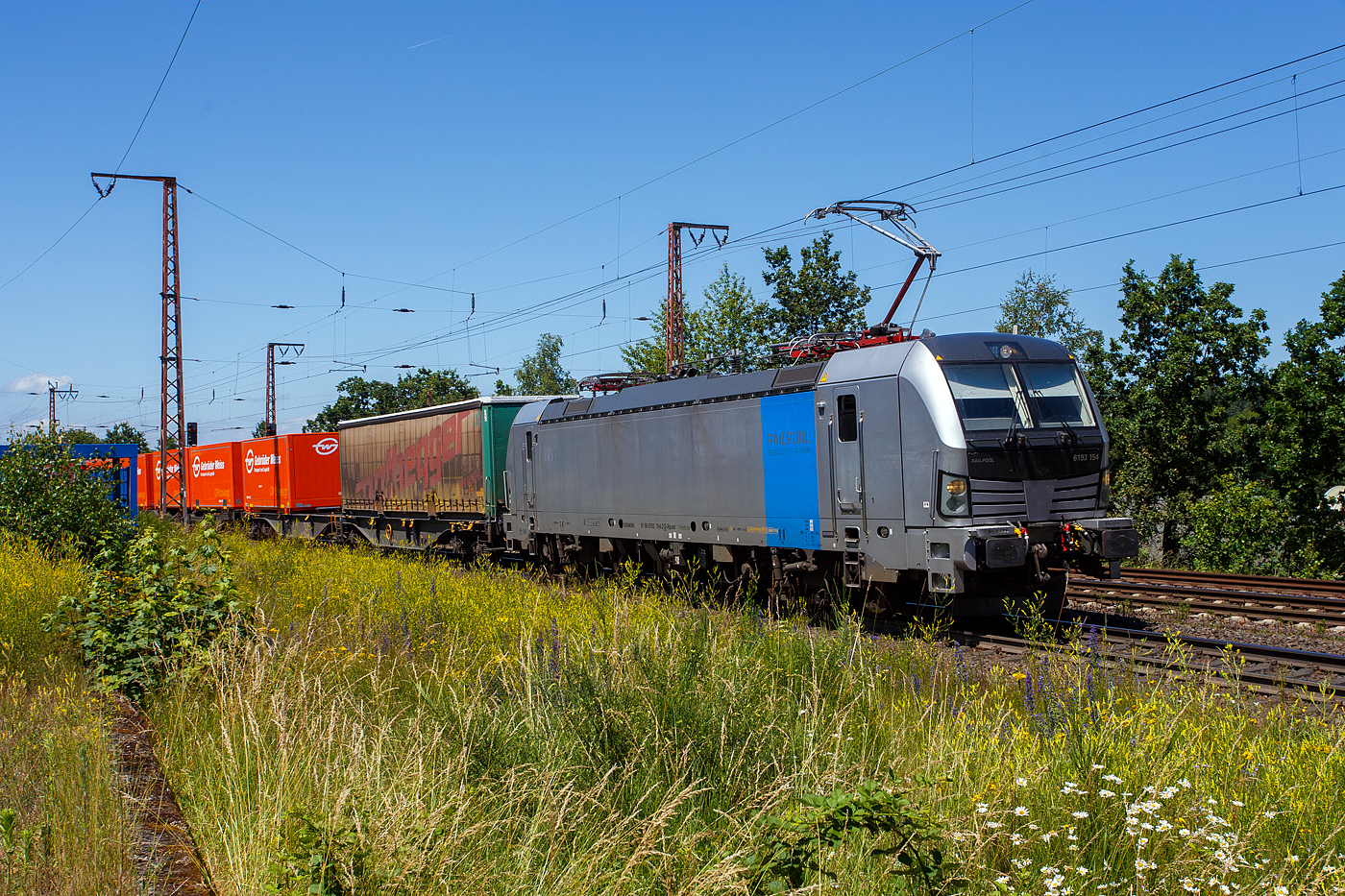 Die an die TX Logistik AG, Troisdorf (zur Mercitalia Group gehörend) vermietete SIEMENS Vectron AC 6193 154-2 (91 80 6193 154-2 D-Rpool) der Railpool GmbH (München) fährt am 28 Juni 2024 mit einem KLV-Zug durch Wilnsdorf -Rudersdorf (Kr. Siegen) in Richtung Süden.

Die Vectron Wechselstromlok (AC 15 kV 16,7 Hz und AC 25 kV 50 Hz) SIEMENS Vectron AC wurde 2023 von Siemens Mobilitiy in München-Allach unter der Fabriknummer 23499 gebaut. Sie wurde in der Vectron Variante AC B18 ausgeführt und hat so die Zulassung für Deutschland, Österreich, Schweden, Norwegen und Dänemark (D / A / S / N und DK). So besitzt die Variante AC B18 folgende  Zugsicherungssysteme:
ETCS BaseLine 3, sowie für Deutschland (PZB90 / LZB80 (CIR-ELKE I)), für Österreich (ETCS Level 1 mit Euroloop, ETCS Level 2, PZB90 / LZB80), 
für Schweden und Norwegen (ATC-2 (L10000)) und für Dänemark ZUB 123.
