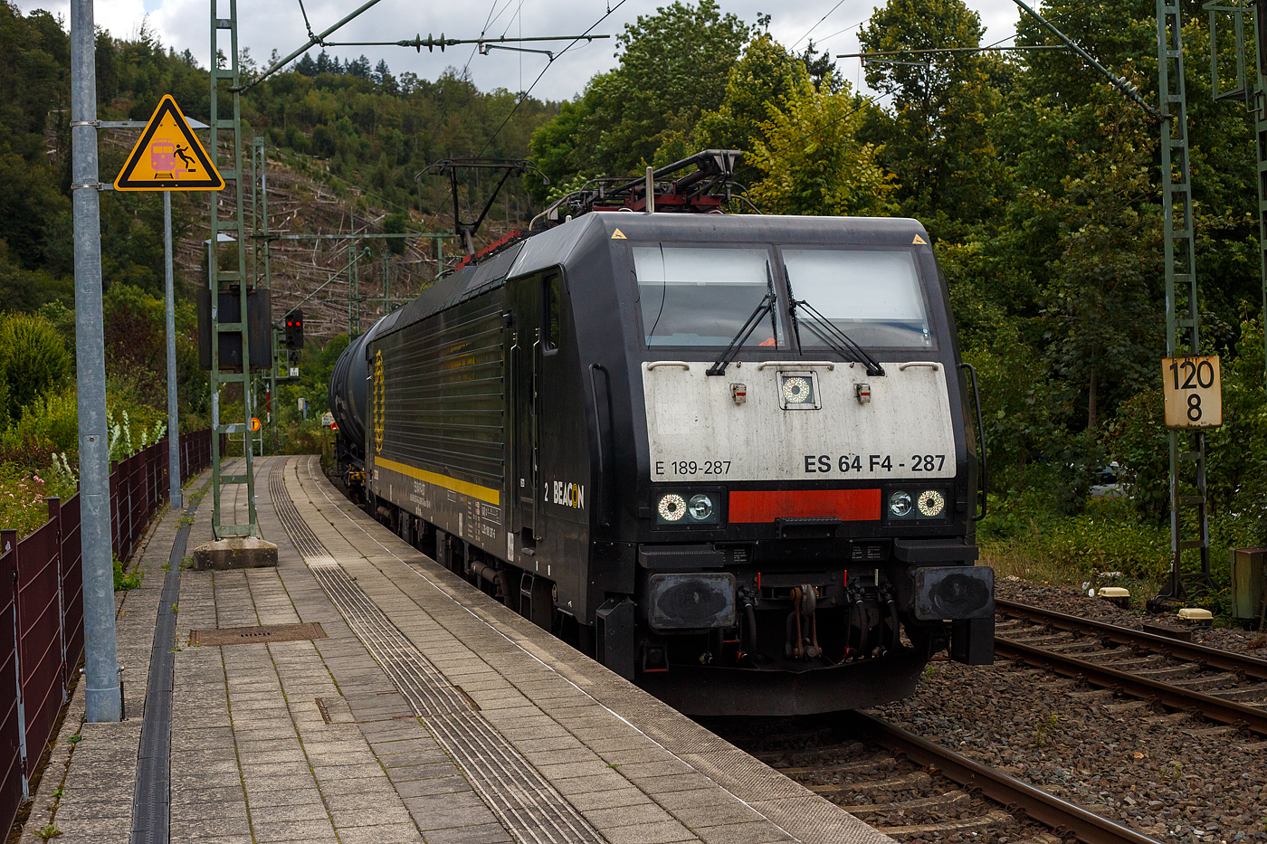 Die Beacon E 189-287 bzw. ES 64 F4 - 287 / LZB 189 287-6 (91 80 6189 287-6 D-DISPO Class 189-VK) der Beacon Rail Capital Europe GmbH, München (ex MRCE Dispolok) fährt am 14 September 2024 mit einem Kerosin-Kesselwagenzug, laut Gefahrguttafel/Warntafel 30/1863 beladen mit Düsenkraftstoff (auch bekannt als Kerosin bzw. leichtes Petroleum) hier laut Anschrift mit der Sorte Jet A-1 (NATO Code F-35), durch den Bahnhof Kirchen (Sieg) in Richtung Siegen.

Die Siemens EuroSprinter wurde 2009 von Siemens in München unter der Fabriknummer 21631 gebaut und an die MRCE - Mitsui Rail Capital Europe GmbH (München) ausgeliefert. Seit September 2023 hat die Beacon Rail Metro Finance B.V. die Mitsui Rail Capital Europe B.V. (Amsterdam) und somit auch die Mitsui Rail Capital Europe GmbH im München übernommen, so firmiert sie nun als Beacon Rail Capital Europe GmbH, München (BRCE / DISPO). Diese Lok hat Zulassung für Deutschland, Österreich und die Niederlande.

Die BR 189 (Siemens ES64F4) hat eine Vier-Stromsystem-Ausstattung. Sie ist in allen vier in Europa üblichen Bahnstromsystemen einsetzbar. Diese hier hat die Variante K (Class 189-VK) und besitzt die Zugbeeinflussungssysteme LZB/PZB, ETCS und ATB für den Einsatz in Deutschland, Österreich und den Niederlanden.
Die Stromabnehmerbestückung ist folgende:
Pos. 1: D, A, NL (AC)
Pos. 2: NL (DC)
Pos. 3: NL (DC)
Pos. 4: D, A, NL (AC)

TECHNISCHE DATEN:
Spurweite: 1.435 mm (Normalspur)
Achsformel: Bo’Bo’
Länge über Puffer: 19.580 mm
Achsabstand im Drehgestell: 2.900 mm
Dienstgewicht: 87 t
Stundenleitung: 6.400 kW bei 15 kV / 25 kV AC; 6.000 kW bei 3 kV DC und 3.000 kW bis 4.200 kW bei 1,5 kV DC
Anfahrzugkraft: 300 kN
Maximale Dauerzugkraft bis 84 km/h; 270 kN
Höchstgeschwindigkeit: 140 km/h
Stromsysteme: 15 kV, 16,7 Hz AC; 25 kV, 50 Hz AC; 1,5 kV und 3 kV DC
