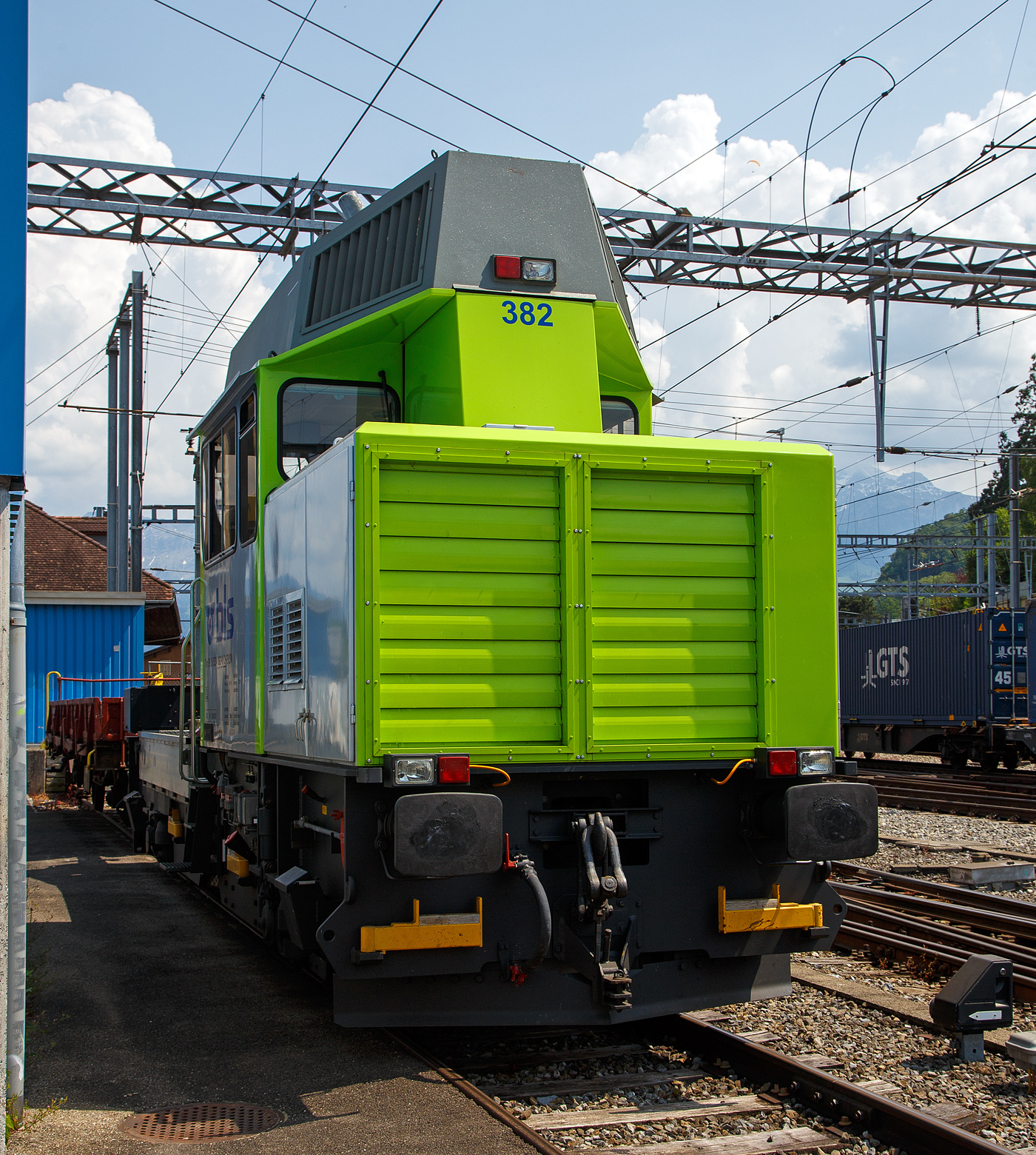 Die BLS „Ameise Lena Alina“ bzw. der Bautraktor Tm 234 382-0 (Tm 98 85 5234 382-0  CH-BLSN) der BLS Netz AG ist am 28.05. 2023 beim Bahnhof Spiez abgestellt.

Der Tm 234 «Ameise» ist ein zweiachsiger Bautraktor der Schweizerischen Bundesbahnen (SBB) und einiger Privatbahnen, wie hier der BLS. Er wurde ab 1997 vom Konsortium Stadler Rail / Bombardier Transportation / Winpro / ADtranz hergestellt. Die letzte Serie wurde von der Stadler Winterthur AG (ehemals Winpro AG) gebaut und 2007 ausgeliefert. Insgesamt wurden ein Prototyp und 132 Serienfahrzeuge gebaut. 

Technik:
Der Hauptmotor ein 12-Zylinder-MTU-Dieselmotor entwickelt eine Leistung von 550 kW, welche er über ein Hydrostatiksystem auf vier Fahrmotoren abgibt. Für die Arbeiten an den Bahnanlagen besitzen die BLS Fahrzeuge einen Palfinger PK 9501Ladekran (bei Tm 234 384 einen Kran mit Korb PKR 090). SBB Fahrzeuge haben meist einen Palfinger PK 9001).

Die maximale Anfahrzugkraft liegt bei 81 kN. Der Traktor kann über eine Funkfernbedienung rangiert werden ( Arbeitsbetrieb ). Es gibt drei verschiedene Betriebsarten: Streckenbetrieb (Höchstgeschwindigkeit 80 km/h); Arbeitsbetrieb (ca. 27 km/h); Kranbetrieb (ca. 5 km/h). Die maximale Zuladung von Material auf der Ladebrücke beträgt 7 Tonnen. Zur Unterstützung und Beleuchtung ist eine Notstromgruppe mit einer Leistung von 15 kW montiert. 

Sämtliche Traktoren sind mit einem Schraubenkompressor mit einer Fördermenge von 800 l/min bei einem maximalen Druck von 10 bar ausgerüstet. 

Weitere Technische Merkmale:
Diesel-Russpartikelfilter Mobiclean S Typ FS 9/400, sowie Katalysator SCR-System zu Mobiclean (Abgasreinigungsanlage zur Reduktion von Stickoxide) aus Platzgründen im Dachaufbau untergebracht.
Kranbedienung und Fahrzeugverschiebung mittels Kran-Funkfernsteuerung
Fahrzeug ist mit 2 Führerpulten ausgerüstet und kann somit auch für Rangierfahrten verwendet werden
Der stufenlos arbeitende Hydrostatik-Antrieb verfügt über sehr gute Langsamfahreigenschaften und bietet volle Zugkraft ab v > 1 km/h, andererseits erlaubt er Geschwindigkeiten bis 80 km/h

TECHNISCHE DATEN:
Spurweite: 1.435 mm
Anzahl der Achsen: 2  (Einzelantrieb alle vier Räder)
Achsabstand: 6.000 mm
Raddurchmesser:  800 mm (neu) / 730 mm (abgenutzt)
Länge über Puffer : 11.220 mm
max. Breite: 2.830 mm
max. Höhe:  4.511 mm
Kleinster befahrbarer Gleisbogen: 80 m
Dienstgewicht:  30 t
Zuladung: 7 t
Dieselmotorleistung: ca. 550 kW (bei 2100 U/min.)
Höchstgeschwindigkeit: 80 km/h (Streckenfahrt) / 100 km/h (geschleppt)
Klotzbremseinheiten: 4 Stück  (3 davon mit integrierten Federspeichern)
Kolbenkompressor:  670 l/min bei 10 bar (effektives Schöpfvolumen)
Hauptluftbehälter: 800 l
nutzbarer Inhalt Treibstofftank: 650 l
