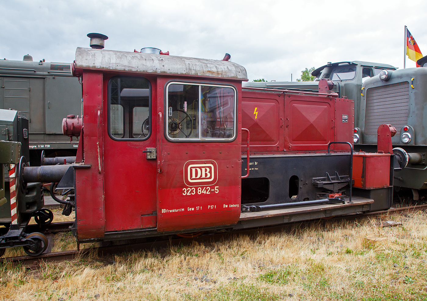 Die ex DB 323 842-5, ex DB Köf 6772, der Westerwälder Eisenbahnfreunde 44 508 e. V., ausgestellt am 02.07.2023 beim Erlebnisbahnhof Westerwald in Westerburg, hier war Lokschuppen-/Sommerfest.

Diese Köf II wurde 1960 unter der Fabriknummer 13210 bei der Lokfabrik Jung in Jungenthal bei Kirchen/Sieg gebaut und als Köf 6772 an die DB ausgeliefert. Sie war eine der 108 Maschinen der LG II, die im Rahmen der vorletzten Beschaffungsmaßnahme der DB, bei der Lokfabrik Jung-Jungenthal gebaut wurden. Zum 01. Januar 1968 erhielt sie, im Rahmen neuen EDV-Nummern, die Umzeichnung in 323 842-5.

Die 323 842-5 (Jung 13210) war ab 1960 dem BW Wetzlar zugeteilt, ab 1968 wurde das Heimatbetriebswerk das Bw Limburg / Lahn, welches zum 01.12.1991 zur Außenstelle des Bw Gießen wurde. Die Zurückstellung von der Ausbesserung (Z-Stellung) erfolgte am 22. Juli 1996 im Bw Gießen, der am 30.08.1996 die Ausmusterung (Bw Gießen) folgte. Ab 1997 stand die Lok der BSW-Gruppe Koblenz, Ortsgruppe Siershahn zur Verfügung. Nach der Gründung des Vereins Westerwälder Eisenbahnfreunde 44 508 e. V. wurde die Lokomotive im Juli 2002 vom Verein käuflich erworben. Am 29.11.2003 wurde die Maschine per Tieflader zum jetzigen Standort ins Westerburger Museum transportiert. Die Lokomotive ist betriebsfähig und verlässt von Zeit zu Zeit den Lokschuppen mit eigener Kraft.

In den Jahren 1932 - 38 beschaffte die Reichsbahn 887 Lokomotiven dieser Baureihe. Durch die Einwirkungen des Krieges stark dezimiert übernahm die spätere Bundesbahn noch 444 Exemplare und ließ, zwischen 1952 und 1965 noch 731 weitere Maschinen der Leistungsgruppe II neu bauen. Diese splitteten sich in die Baureihen 322, 323 und 324. Loks der BR 322 hatten eine Höchstgeschwindigkeit von 30 km/h, die Loks der BR323 hatten eine Höchstgeschwindigkeit von 45 km/h. Die zahlenmäßig größte Baureihe waren die Kleinloks der Baureihe 323. Dabei wurden ursprünglich zwei Gruppen unterschieden, 323 001 - 323 499 mit Deutz-Motor sowie 323 501 - 323 999 mit Kaelble-Motor. Insgesamt gab es 892 Loks der Baureihe 323.

Der Antrieb erfolgt Dieselhydraulisch, d.h. die Kraftübertragung erfolgt vom Motor auf ein Voith-Turbogetriebe und von diesem über Rollenketten auf die beiden Achsen. Die Hersteller waren Gmeinder, O&K, Krupp, KHD, BMAG, Borsig, Jung und Henschel. Die Baureihe hat ausgedient und ist nur noch vereinzelt in div. Museen anzutreffen.

TECHNISCHE DATEN:
Spurweite: 1435 mm (Normalspur)
Achsfolge : B
Länge über Puffer: 6.450 mm
Achsabstand: 2.500 mm
Treibraddurchmesser:	850 mm (neu)
größte Breite: 3.050 mm
größte Höhe: 2.890 mm
Dienstgewicht: 17 t 
Motorenart: wassergekühlter 6-Zylinder- Reihendieselmotor vom Typ Kaelble GN130 s
Leistung: 128 PS (94 kW) bei 1300 U/min.
Motorhubraum: 14,33 Liter (Bohrung 130 mm x 180 mm Hub)
Getriebe: Voith L33U
Höchstgeschwindigkeit: 45 km/h 
Anfahrzugkraft: 27,5 kN
Die Kraftübertragung vom Getriebe auf die Achsen erfolgt über Rollenketten.
