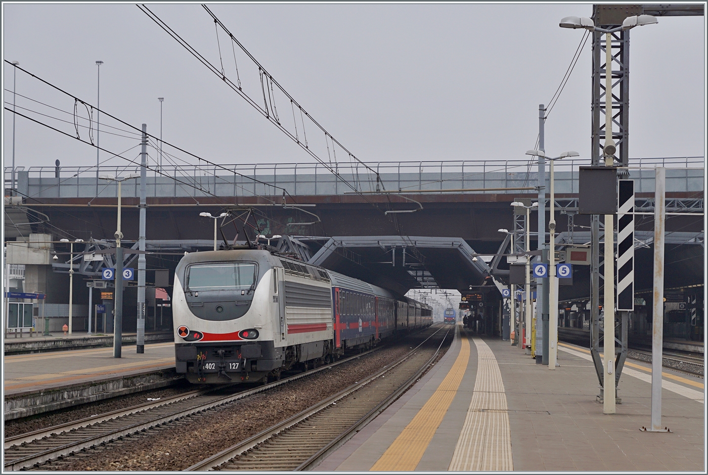 Die FS Trenitala E 402 120 und am Schluss des Zuges die 402 127 sind mit dem Treno di notte ICN 798 von Salerno nach Torino unterwegs. Der Zug erreicht den Bahnhof Rho Fiera Milano wo der ohne Halt durch fährt.

24. Februar 2023