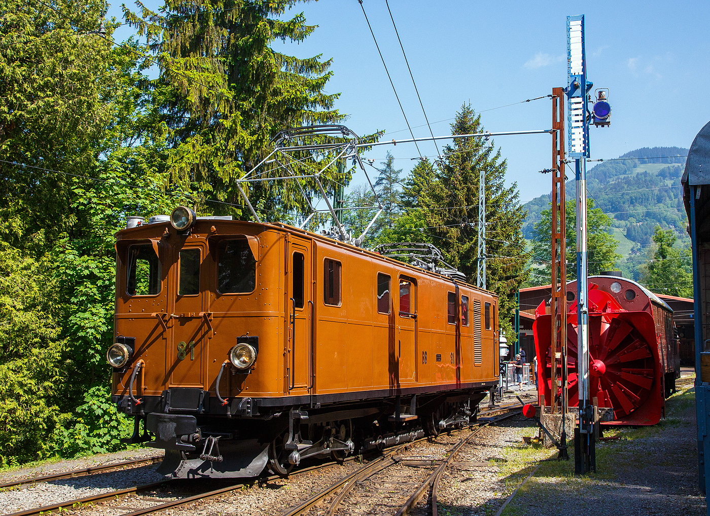 Die grandiose ehemalige Berninabahn RhB Ge 4/4 81 der Museumsbahn Blonay–Chamby, ex RhB Ge 4/4 181, ex BB Ge 4/4 81, ex BB Ge 6/6 81, am 27. Mai 2023 beim Umsetzen auf dem Museums-Areal der (BC) in Chaulin. 

Rechts ein Schweizer Rangiersignal (Räumungssignal), welches hier zeigt „Rangieren gestattet“ (im Gültigkeitsbereich des Signals ist keine Zufahrtsstraße eingestellt). Bei Rangieren verboten wären die Flügel zu einem X gekreuzt. 

Hinter dem Signal ein weiteres Relikt der Berninabahn, die Selbstfahrende Dampfschneeschleuder R 1052 (ex BB R 1052 (Berninabahn), ex RhB R 14, ex RhB Xrot d 9214) der Museumsbahn Blonay-Chamby.

