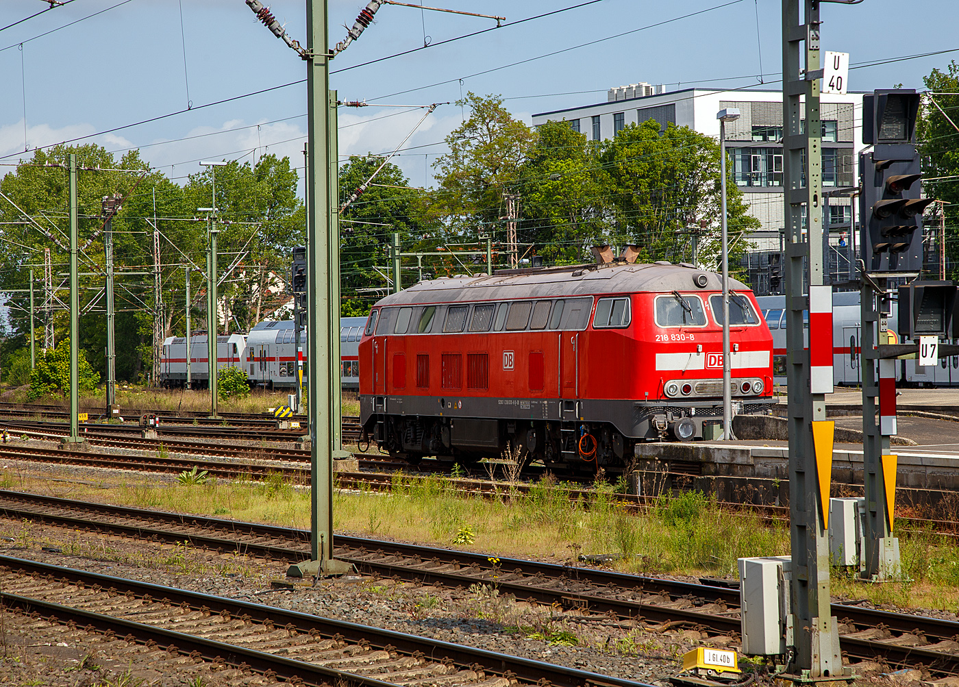 Die ICE-Schlepplok 218 830-8 (92 80 1 218 833-2 D-DB) der DB Fernverkehr AG, ex DB 218 305-1, ist am 14 Mai 2022 beim Hauptbahnhof Hannover abgestellt. 

Die V 164 wurde 1974 von der Friedrich Krupp AG in Essen unter der Fabriknummer 5298 gebaut und als 218 305-1 an die Deutsche Bundesbahn geliefert. Im März/April 2005 erfolgte der Umbau zur Schlepplok und Umzeichnung in 218 830-8.

Die Baureihe 218 ist das zuletzt entwickelte Mitglied der V 160-Lokfamilie. Viele Gemeinsamkeiten der Baureihen V 160 bis V 169 (spätere 215 bis 219) wurden in ihr zusammengefasst. Bei der Baureihe 218 wurde von der Baureihe 217 die elektrische Zugheizung übernommen, von den Prototypen der Baureihe 215 übernahm man den 1840-kW-Motor (2500 PS), wobei ein Hilfsdieselmotor zum Betrieb des Heizgenerators überflüssig wurde.

Im Jahr 1966 bestellte die Deutsche Bundesbahn zunächst zwölf Vorserien-Lokomotiven der Baureihe V164. Die ersten Lokomotiven wurden ab 1968 von der Firma Krupp ausgeliefert. Von der Deutschen Bundesbahn wurden sie aber als Baureihe 218 in Dienst gestellt. Die Serienbeschaffung (unter Beteiligung von Henschel, Krauss-Maffei und MaK in Kiel) erfolgte von 1971 bis 1979 mit 398 weiteren Maschinen. Hinzu kam 1975 nach einem Unfall die 215 112, die nach ihrer Instandsetzung zur 218 399 wurde. Die Auslieferung erfolgte in vier Bauserien (218 101-170, 171-298, 299-398, 400-499), bei denen es geringe Veränderungen gab.

Die 140 km/h schnellen und 2500 bis 2800 PS starken ''BB-Loks wurden im Reise - und Güterzugdienst eingesetzt. Die elektrische Zugheizung und die Wendezug- und Doppeltraktionssteuerung machen die Baureihe 218 zu einer universal verwendbaren Lok. Die Baureihe 218 bewährte sich im Betriebsdienst und galt noch bis ins Jahr 2000 als die wichtigste Streckendiesellok der Deutschen Bahn AG. Leider wurden immer mehr Leistungen im Personennahverkehr durch Triebwagen ersetzt. Dadurch und durch Betreiberwechsel waren immer mehr Lokomotiven der Baureihe 218 bei der Deutschen Bahn AG überflüssig geworden. Im Juli 2009 waren noch etwa 200 Exemplare im Einsatz. Eine Nachfolgerin für die Baureihe 218 ist noch nicht in Sicht.

Baureihe 218.8
Einige Lokomotiven der Baureihe 218 wurden zu Schlepploks für liegengebliebene oder schadfällig gewordene ICE -Züge auf den Neubaustrecken Köln-Rhein/Main und Nürnberg-Ingolstadt umgebaut. Diese Loks sind als Baureihe 218.8 bei der DB Fernverkehr AG eingestellt. Diese Lokomotiven wurden für Schleppzwecke mit Übergangskupplungen Typ Scharfenberg ausgerüstet. Für die DB Regio AG sind die Maschinen 218 228 im Bereich der S-Bahn Rhein-Main und 218 191 im Bereich der S-Bahn Stuttgart für Schlepp- und Rangierarbeiten eingesetzt.
Insgesamt wurden bisher 15 Loks im Ausbesserungswerk Bremen zur 218.8 umgebaut. Die im S-Bahnbereich eingesetzten, nicht umnummerierten Abschlepploks, sind in Frankfurt/Main und Plochingen beheimatet.
Die Lokomotiven der Baureihe 218.8 teilen sich auf die Betriebshöfe Frankfurt/Main (elf Loks) und Berlin -Rummelsburg (sechs Loks) auf. Die Loks stehen in mehreren Bahnhöfen bereit und sind buchmäßig in Frankfurt und Berlin-Rummelsburg erfasst.

TECHNISCHE DATEN:
Spurweite: 1.435 mm (Normalspur)
Achsformel:  B'B'
Spurweite:  1.435 mm
Länge: 16.400 mm
Drehzapfenabstand:  8.600 mm
Achsabstand im Drehgestell: 2.800 mm
Gewicht:  79 Tonnen
Achslast: 20 t
Höchstgeschwindigkeit:  140 km/h
Motor: Wassergekühlter V 12 Zylinder Viertakt MTU - Dieselmotor vom Typ 12 V 952 TB 10 mit Direkteinspritzung und Abgasturboaufladung mit Ladeluftkühlung
Motorleistung: 1.839 kW (2.500 PS) bei 1.500 U/min
Anfahrzugkraft: 235kN / Dauerzugkraft: 175kN
Getriebe: MTU-Getriebe K 252 SUBB (mit 2 hydraulische Drehmomentwandler)
Leistungsübertragung: hydraulisch
Tankinhalt:  3.150 l
Bremse: KE-GPP-R-H mZ
Besonderheiten: doppeltraktionsfähig / wendezugfähig ,elektrische Zugsammelschiene
