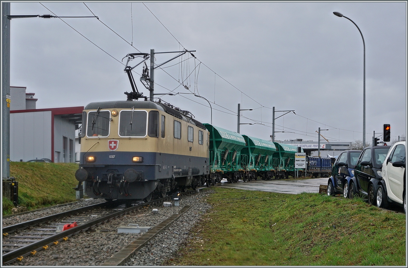 Die IRSI/IGE  Rheingold  Re 4/4 II 11387 (Re 421 387-2) im Dienste der BAM MBC verlässt mit ihrem Kieszug nach Apples das Industriegelände bei Gland.

22. Feb. 2024 