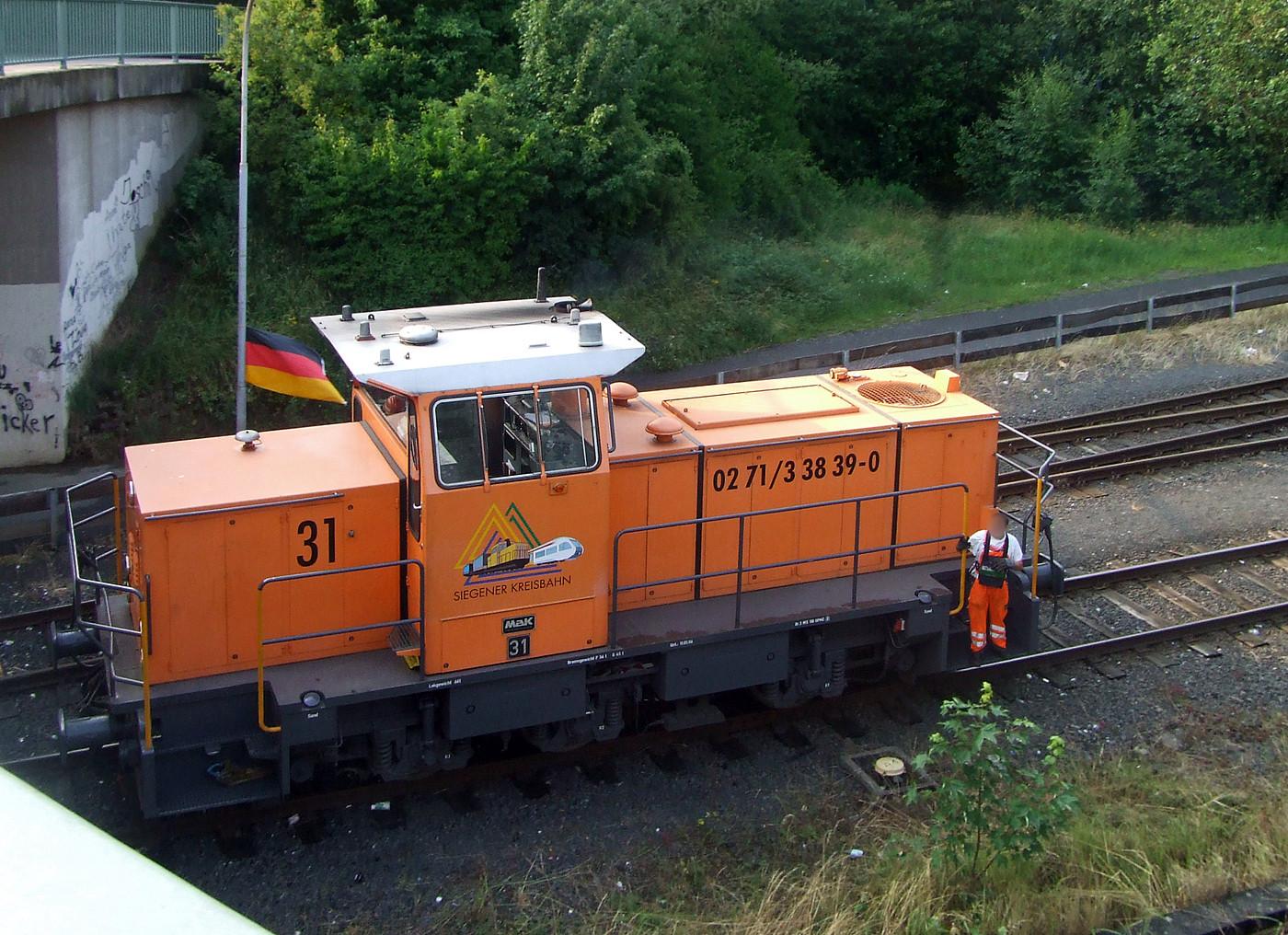 Die KSW 31, eine MaK G 763 C der Kreisbahn Siegen-Wittgenstein GmbH, rangiert am 25 Juni 2008 in Herdorf auf dem KSW-Rangierbahnhof in Herdorf (Betriebsstätte FGE -Freien Grunder Eisenbahn)

Die KSW 31 wurde 1989 von MaK in Kiel unter der Fabriknummer 700093 gebaut und als SK 31 an die Siegener Kreisbahn GmbH geliefert, welche ab Ende 2004 nun als Kreisbahn Siegen-Wittgenstein (KSW) firmiert. Die Lok wurde im Juni 2008 an die Vossloh Locomotives GmbH Kiel-Friedrichsort) verkauft und bekam nun die NVR-Nr. 92 80 0262 217-9 D-VL, bis Mitte Januar 2009 war sie dann noch an die KSW vermietet. 2009 war sie dann bei der ThyssenKrupp Steel AG im Werk Kreuztal-Ferndorf. Im Februar 2011 wurde sie dann an die VGH - Verkehrsbetriebe Grafschaft Hoya GmbH, Lok 22 (98 80 0262 217-9 D-VGH) verkauft.

Die Lokomotive MaK G 763 C ist eine dieselhydraulische Lokomotive, die von der Maschinenbau Kiel (MaK) gebaut wurde. Sie wird dem 3. Typenprogramm von MaK, das ab 1977 angeboten wurde, zugerechnet. Sie stellt die Nachfolgerin der in 18 Exemplaren gebauten MaK G 761 C dar, unterscheidet sich von dieser durch einen stärkeren MTU-Motor Reihe 396 und hat ein anderes Getriebe. Die Führerhäuser waren aus Sicherheitsgründen nicht mehr direkt vom Boden, sondern nur über den Umlauf erreichbar. Die MaK G 763 C hat drei im Rahmen sitzende Achsen, die über Gelenkwellen angetrieben werden. Sie hat eine Leistung von 560 kW und erreicht eine maximale Geschwindigkeit von bis zu 40 km/h. Sie bringt es auf eine Dienstmasse von bis zu 66 t. Ihr Tankinhalt beträgt 1.500 l.

Von der MaK G 763 C wurde zwischen 1982 und 1993 insgesamt 27 Exemplaren gebaut. Größte Abnehmer mit jeweils drei Lokomotiven waren die Siegener Kreisbahn und die Städtischen Häfen Hannover. Alle Lokomotiven befinden sich noch im Dienst. Im Deutschen Fahrzeugeinstellungsregister wurde für diese Bauart die Baureihennummer 98 80 0262 vergeben.

Technische Daten:
Spurweite: 1435 mm
Achsfolge: C
Länge über Puffer: 9.870 mm
Achsstand: 3.800 mm
größte Breite: 3.100 mm
größte Höhe über Schienenoberkante: 4.220 mm
Raddurchmesser neu: 1.000 mm
kleinster befahrbarer Gleisbogen: 40 m
Dienstgewicht: 54 - 66 t (diese 64 t)
Motor: Sechszylinder-MTU-Dieselmotor, Typ 6V 396 TC13
Leistung: 560 kW
Drehzahl: 1.800 U/min
Getriebe: Voith, Typ L3r4U2
Leistungsübertragung: hydraulisch
Höchstgeschwindigkeit: 32 - 40 km/h
Kraftstoffvorrat: 1.500 l
