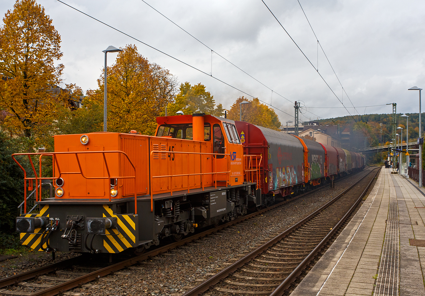 Die KSW 45 (98 80 0276 016-9 D-KSW) die MaK G 1204 BB der Kreisbahn Siegen-Wittgenstein fährt am 26 Oktober 2023 mit einem Coilzug durch den Bahnhof Kirchen/Sieg nach Betzdorf/Sieg. Die Lok 45 der KSW (MaK G 1204 BB) ist mit ihrer Leistung von 1.120 kW (1.522 PS) die schwächste der KSW und daher kaum vor den Coilzügen zusehen, aber ihr mit 10 Wagen sind es nur ca. 1.000 t am Haken. 

Nun hat sie Hp 1 (grün) und sie gibt Dampf / Gas, war man hier gut sehen kann. Der MTU-V12-Zylinder-Dieselmotor mit Common-Rail-Einspritzung, Abgasturboaufladung und Ladeluftkühlung vom Typ MTU 12V 396 TC13 braucht da bald mal eine Überholung.

Nochmals einen lieben Gruß an das nette KSK Lokpersonal (Lokführer und Rangierbegleiter) zurück.

Die Lok ist übrigens eine ehemalige Schweizerin, sie wurde 1991 unter der Fabriknummer 1000866 bei MaK in Kiel gebaut und an die Sersa AG (Zürich) als Am 847 953-7  Bettina  geliefert. Im Jahr 1998 ging sie wieder nach Deutschland zur MaK / Vossloh Locomotives zurück, wo sie als Mietlok zur Verfügung stand. Nach mehreren Stationen als Mietlok (u.a. 2006 auch bei der KSW) wurde sie dann 2007 von der KSW gekauft und am 23.08.2007 nach Siegen überführt.