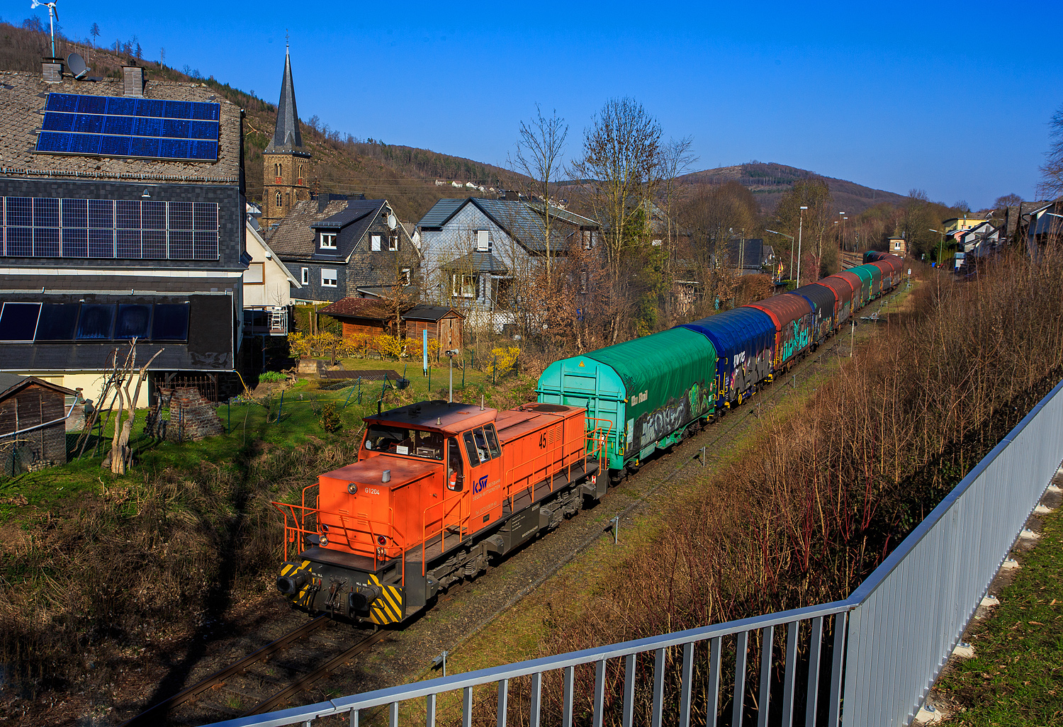 Die KSW 45 (98 80 0276 016-9 D-KSW), die MaK G 1204 BB der Kreisbahn Siegen-Wittgenstein fährt am 19 März 2026 mit einem Übergabezug (leere Coil-Wagen) von Herdorf nach Betzdorf/Sieg.

Nochmals einen lieben Gruß an den netten Lokführer zurück.

Die MaK G 1204 BB ist mit 1.120 kW (1.522 PS) die schwächste Lok der KSW. Die Lok ist übrigens eine ehemalige Schweizerin, sie wurde 1991 unter der Fabriknummer 1000866 bei MaK in Kiel gebaut und an die Sersa AG (Zürich) als Am 847 953-7  Bettina  geliefert. Im Jahr 1998 ging sie wieder nach Deutschland zur MaK / Vossloh Locomotives zurück, wo sie als Mietlok zur Verfügung stand. Nach mehreren Stationen als Mietlok (u.a. 2006 auch bei der KSW) wurde sie dann 2007 von der KSW gekauft und am 23.08.2007 nach Siegen überführt.