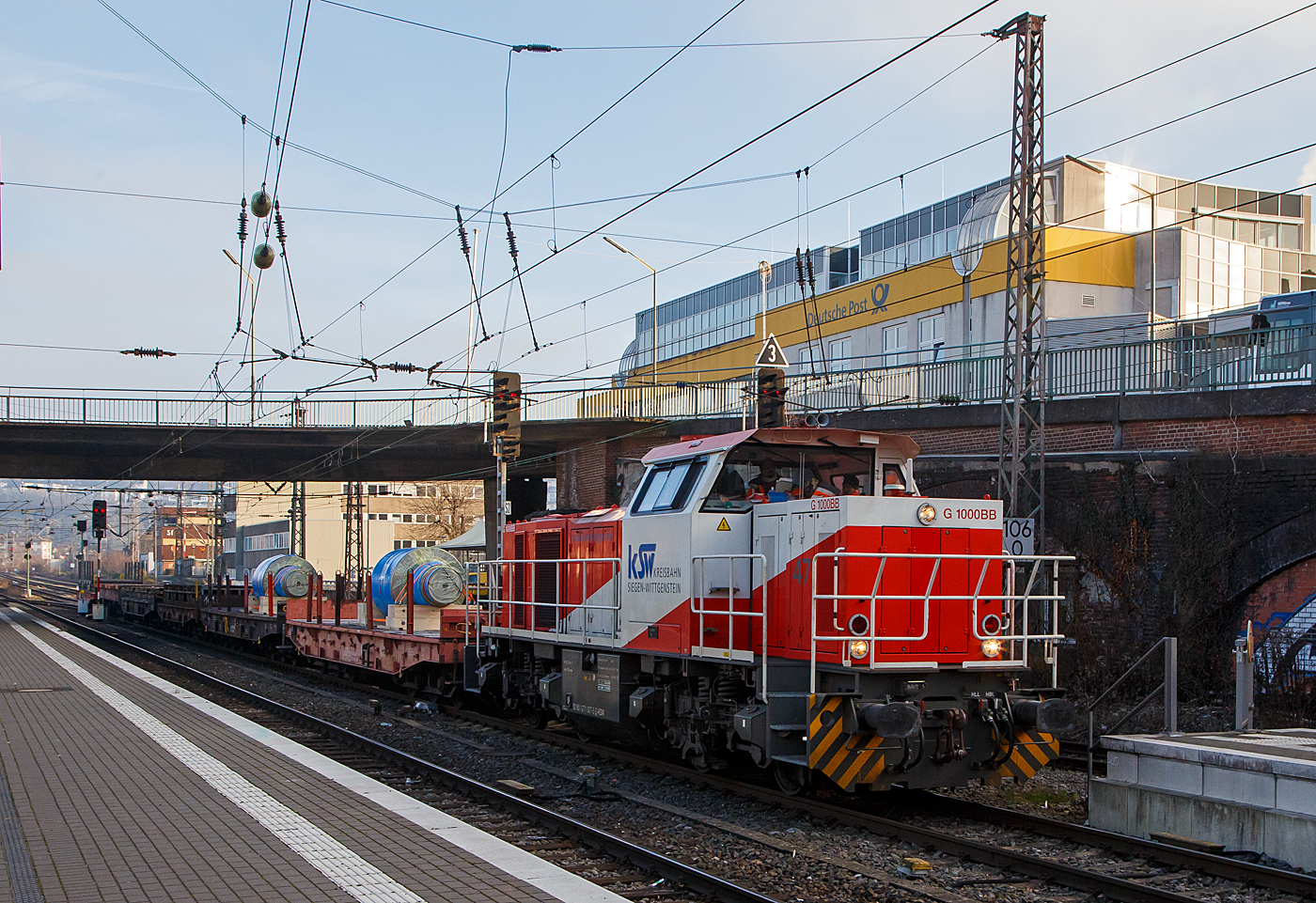 Die KSW 47 (92 80 1271 027-5 D-KSW), ex D 2 der HFM, eine Vossloh G 1000 BB der KSW (Kreisbahn Siegen-Wittgenstein), fährt am 15.12.2022 von Siegen-Ost kommend mit einem Walzenzug (Schwerlastwagen beladen mit gegossenen Walzen) durch den Hauptbahnhof Siegen in Richtung Siegen-Eintracht (zur KSW Zentrale).

Nochmals einen lieben Gruß ans nette KSW Personal zurück.
