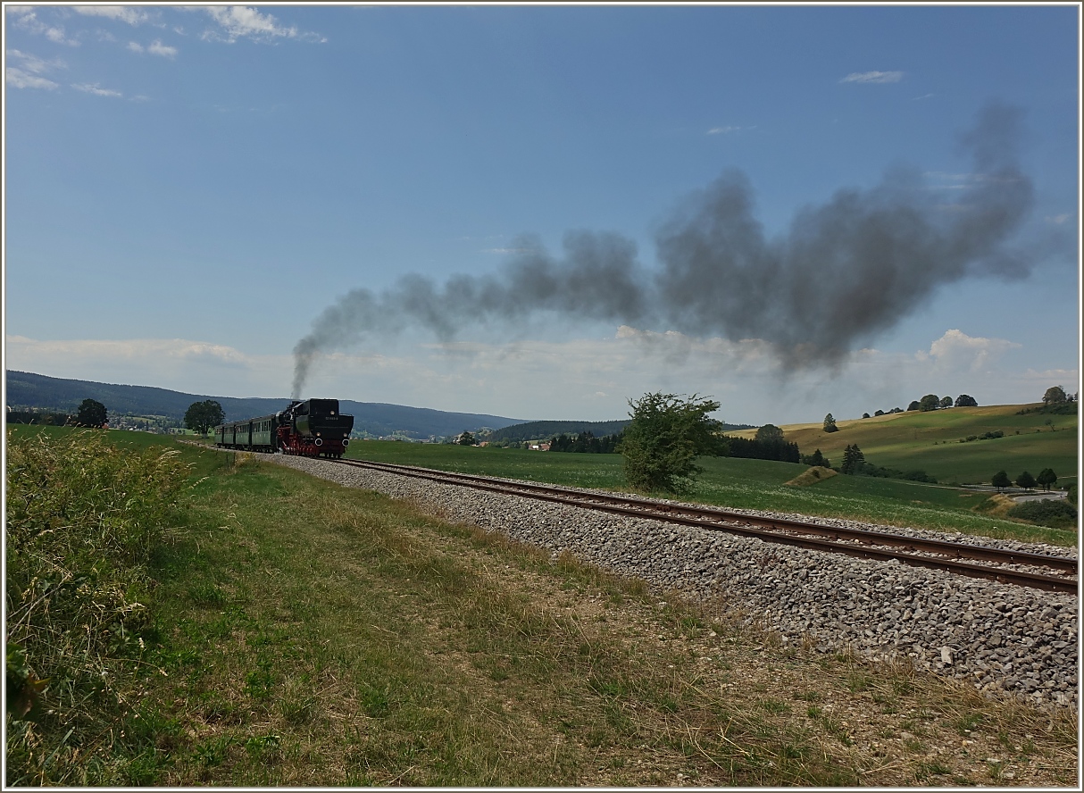 Die Lokomotive ex DR 52 8163-9 dampft durch die Landschaft des Jura bei Le Touillon.
(15.07.2023)
