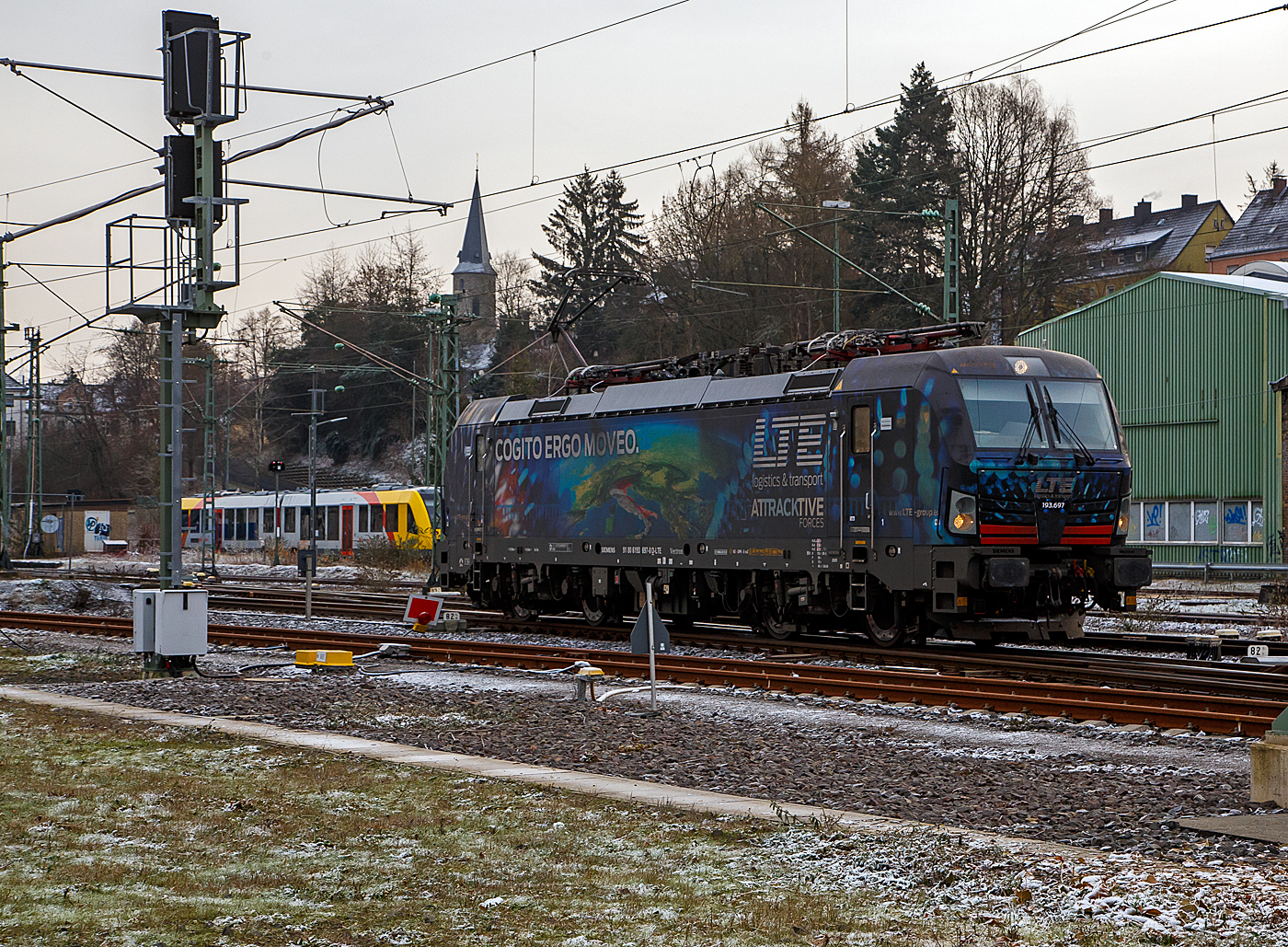 Die LTE 193.697   Cogito Ergo Moveo  (91 80 6193 697-0 D-LTE) der LTE Logistik- und Transport GmbH (Graz) fährt am kalten 18.12.2022 (4. Advent), als Lokzug (Lz) bzw. auf Triebfahrzeugfahrt (Tfzf), durch Betzdorf (Sieg) in Richtung Köln.

Die Siemens X4E bzw. Siemens Vectron MS in der Variante A35 wurde 2020 von Siemens Mobilitiy in München-Allach unter der Fabriknummer 22764 gebaut und war kurzzeitig als Siemens Mietlok (91 80 6193 697-0 D-SIEAG) unterwegs und wurde am 9. März 2021 an die LTE Logistik- und Transport GmbH (Graz) verkauft, auch in schwierigen Zeiten setzt LTE weiterhin auf Expansion. Die Vectron MS in der Variante A35 mit einer Leistung von 6.4 MW (unter Wechselstrom) kann in12 Ländern fahren. Sie hat die Zulassungen für Deutschland, Österreich, Italien, Ungarn, Tschechien, Polen, Slowakei, Kroatien, Slowenien, Serbien, Bulgarien und Rumänien (D/A/I/H/CZ/PL/SK/ HR/SLO/SRB/BG/RO).

Grundsätzlich sind die neuen Lokomotiven für den Einsatz von und nach Italien vorgesehen. Sie haben aber auch Zulassungen für Österreich, Deutschland, Ungarn, Tschechien, Slowakei, Polen, Slowenien, Kroatien, Serbien, Bulgarien und Rumänien.

LTE logistics & transport wird von Bahnliebhabern auch für das gelungene Design ihrer Lokomotiven geschätzt. Es stammt abermals vom Büro Barus Design, das sich für diesen Anlass den klassischen Philosophen gewidmet hat: „moveo, ergo sum“, das ist Latein  und bedeute „Ich bewege mich, also bin ich“ 

Der hier zusehende lateinische Spruch  Cogito Ergo Moveo  bedeutet „Ich denke, also bewege ich mich“

TECHNISCHE DATEN der Vectron MS:
Spurweite: 1.435 mm
Achsformel: Bo'Bo'
Länge über Puffer: 18.980 mm
Drehzapfenabstand: 9.500 mm
Achsabstand im Drehgestell: 3.000 mm
Raddurchmesser : 1.250 mm (neu) / 1.170 mm (abgenutzt)
Breite (über Handstangen): 3.012 mm
Höhe (Panto abgesenkt): 4.248 mm 
Gewicht:  90 t
Spannungssysteme:  15 kV, 16,7 Hz AC / 25 kV, 50 Hz AC / 1,5kV DC / 3 kV DC
Antriebsleistung am Rad: 6.400 kW (unter Wechselstrom),  6.000 kW unter 3 kV DC und 3.500 kW unter 1,5kV DC
Anfahrzugkraft: 340 kN
Dauerzugkraft: 250 kN
Dynamisches Bremssystem Elektrodynamische Hochleistungs-Rückspeisebremse, für DC Netze zusätzlich Widerstandsbremse.
Leistung der dynamischen Bremse (AC/DC:  6.400 kW / 6.000 kW, Leistung der Widerstandsbremse: 2.600 kW
Max. Bremskraft der dynamischen Bremse: 150 - 240 kN
Höchstgeschwindigkeit: 160 km/h (200 km/h)
Kraftübertragung: Ritzelhohlwellenantrieb
Kleinster befahrbarer Gleisbogen:  R = 80 m
Volumina Betriebsstoffe: Sandbehälter 4 x 60 l; Wischwasserbehälter 2 x 28 l und Spurkranzschmierung 13 l
Bremsbauart KE-GPR-E m Z, 

Quelle der Daten: Siemens, ÖBB, LTE und Alfa

