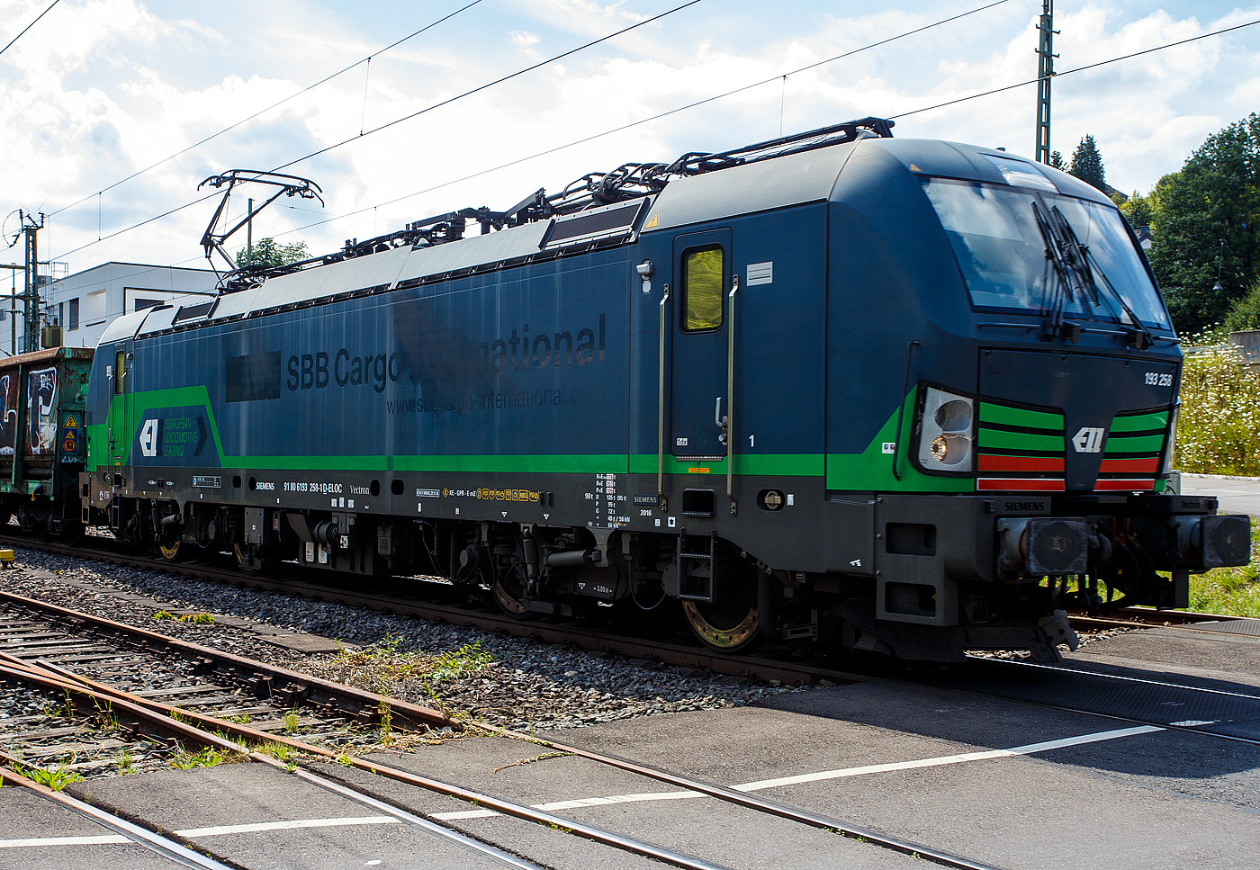 Die nun an die ecco-rail GmbH vermietete SIEMENS Vectron MS 193 258 (91 80 6193 258-1 D-ELOC) der ELL - European Locomotive Leasing (Wien) fährt am 22 Juli 2024, mit einem offen Güterzug (offene Güterwagen der Sonderbauart der Gattung Fas E78.6 der ERMEWA) durch Niederschelden in Richtung Siegen. Zwischen 2016 und 2023 war die Lok an die SBB Cargo International, was man doch noch erkennen kann. Stefan hatte sie als solche mal im Juli 2018 vor der Linse, siehe http://hellertal.startbilder.de/bild/schweiz~strecken~alte-hauensteinlinie-olten-laeufelfingen-sissach-2/619762/die-beiden-193-258-und-461.html

Die Multisystemlokomotive Siemens Vectron MS wurde 2016 von Siemens Mobilitiy in München-Allach unter der Fabriknummer 22154 gebaut.

Diese Vectron Lokomotive ist als MS – Lokomotive (Mehrsystemlok) mit 6.400 kW Leistung und 160 km/h Höchstgeschwindigkeit konzipiert. Hier in der Variante Vectron MS A 22 hat sie die Zulassungen für Deutschland, Österreich, Schweiz, Italien und die Niederlande (D/A/CH/I/NL).Die SIEMENS Vectron MS der Version A 22 besitzt die Zugsicherungssysteme ETCS BaseLine 3, sowie
für Deutschland (PZB90 / LZB80 (CIR-ELKE I)), 
für Österreich (ETCS Level 1 mit Euroloop, ETCS Level 2, PZB90 / LZB80),
für die Schweiz (ETCS Level 2, ZUB262ct, INTEGRA)
für Italien (SCMT)
und für die Niederlande (ETCS Level 1, ETCS Level 2, ATB-EGvV)

Der Lokmieter, die ecco-rail GmbH ist ein österreichisches Eisenbahnverkehrsunternehmen mit Sitz in Wien und wurde 2011 gegründet. Das Unternehmen befördert Güterzüge in Europa, hauptsächlich jedoch in Österreich und Deutschland. Das Unternehmen setzt moderne Elektrolokomotiven ein, welche von Lokomotivvermietern angemietet werden. Im Bestand sind unter anderem Lokomotiven der Baureihen 185 bzw. 187 (angemietet von Railpool), 189 (angemietet von Beacon Rail Capital Europe, ex MRCE) und 193 (angemietet von Railpool sowie ELL Austria), sowie zwei Lokomotiven vom Typ Stadler Eurodual (BR 2159) und zwei vom Typ Euro 9000 (BR 2019). Die Stadler Lokomotiven werden von European Loc Pool angemietet.