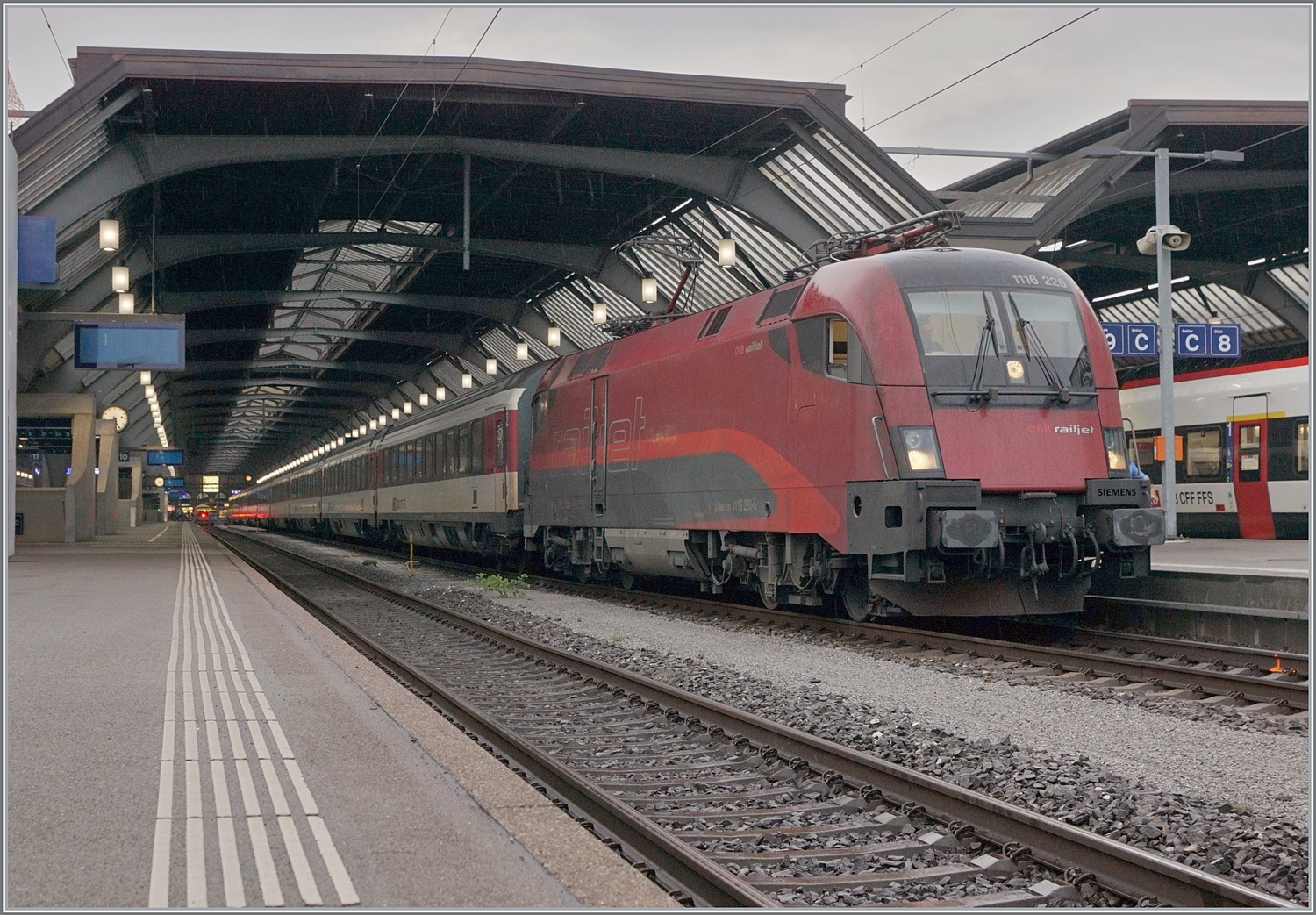 Die ÖBB 1116 220 wartet in Zürich mit ihrem EuroCity  Transalpin  mit der Zugsnummer EC 19793 nach Graz auf die baldige Abfahrt. Zwar sind ÖBB Lokomotiven in Zürich HB keine Seltenheit, aber sie kommen jeweils mit RJ-Garnituren nach Zürich. Eine ÖBB 1116 vor SBB Wagen hingegen stellt schon die Ausnahme dar. Der Zug ist aus drei SBB B, einem SBB A einem ÖBB WR, einem ÖBB A und einem ÖBB (B)D formiert, wenn meine Erinnerung stimmen. Da dieses Bild beim Umsteigen entstand, hatte ich nicht die Zeit, mir den ganzen Zug in Ruhe anzusehen. 
Der EC 19793  Transalpin  hat infolge Bauarbeiten den ungewohnten Laufweg Zürich (ab 8:33) - Bregenz - München - Salzburg - Schwarzach St. Veit Bischofshofen - Leoben - Graz (an 21:32) und wird somit 12 Stunden und 59 Minuten unterwegs sein. 

19. Okt. 2023