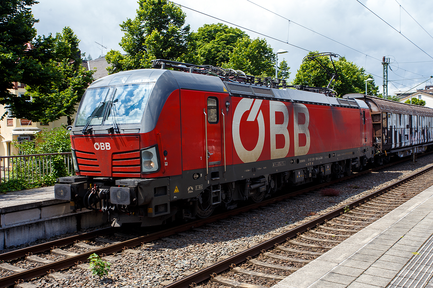 Die ÖBB 1293 190-5 (91 81 1293 190-5 A-ÖBB), eine Siemens Vectron MS (X4E) der Variante A60 (Länderpaket) fährt am 04 Juli 2024 mit einem gedeckten Güterzug (Schiebewandwagen) durch Kirchen(Sieg) in Richtung Köln.

Die Siemens Vectron MS / X4E wurde 2020 von Siemens in München-Allach unter der Fabriknummer 22839 und an die ÖBB - Österreichische Bundesbahnen (ÖBB-Produktion GmbH) geliefert. Sie ist in der Variante A60 auf geführt und hat so die Zulassungen für A / D / CZ / PL / SK / H / RO / BG / HR /SRB / NL / B, wobei noch einige Länder noch durchgestrichen sind. Von der Variante A60 hat die ÖBB 2019 insgesamt 28 Loks (1293 173 bis 1293 200) abgerufen.

Ende Januar 2017 unterzeichneten die Österreichischen Bundesbahnen und Siemens Mobility einen Rahmenvertrag über bis zu 200 Lokomotiven, wovon die ersten 30 Mehrsystem-Vectron direkt zum Gesamtpreis von 120 Mio. Euro abgerufen wurden.

Die Siemens Vectron weisen im Betrieb mit Wechselspannung eine Leistung von 6.400 kW, mit Gleichspannung 6.000 kW, auf und haben eine Masse von bis zu 90 Tonnen, die auf vier Achsen verteilt eine Achslast von 22,5 Tonnen ergibt. Aufgrund der überwiegenden Verwendung im Güterverkehr sind die Lokomotiven zunächst für 160 km/h zugelassen. Zur Verbesserung der Laufeigenschaften auf kurvenreichen Strecken wurden die Lokomotiven mit aktiven Drehdämpfern ausgerüstet

TECHNISCHE DATEN:
Spurweite: 1.435 mm (Normalspur)
Achsformel: Bo’Bo’
Länge über Puffer: 18.980 mm
Breite (über Handstangen): 3.012 mm
Höhe (Panto abgesenkt): 4.248 mm
Begrenzungslinie: UIC 505-1
Drehzapfenabstand: 9.500 mm
Achsabstand in Drehgestell: 3.000 mm
Raddurchmesser: 1.250 mm (neu) / 1.160 mm (abgenutzt)
Dienstgewicht: 90 t
Max. Radsatzlast : 22,5 t
Meterlast: 4.742 kg
Höchstgeschwindigkeit: 160km/h
Antriebsleistung: 6.400 kW (AC) / 6.000 kW (DC)
Anfahrzugkraft: 340 kN
Kleinster bef. Halbmesser: 80 m
Stromsysteme: 15kV/16,7Hz; 25kV/50Hz; 3kV DC (1,5kV DC)
Antriebsart: IGBT Stromrichter und Drehstrom Fahrmotore mit
Antrieb: Ritzelhohlwellenantrieb
Bremsbauart: KE-GPR-E m Z, (D), ep. Dynamisches Bremssystem Elektrodynamische Hochleistungs-Rückspeisebremse, für DC Netze zusätzlich Widerstandsbremse
Leistung der dynamischen Bremse: 6.400 kW (AC) / 6.000 kW (DC), Leistung der Widerstandsbremse: 2.600 kW (DC)
E-Bremskraft der dynamischen Bremse: 150 / 240 kN
Federspeicherbremse 45 / 50: 60 kN
Zugheizung: 900 kVA
Betriebliche Daten:
Zugbeeinflussungssysteme: Alstom IVC ETCS L1-2 + SCMT; LZB 80/E, PZB 90; MIREL VZ1; SHP
Sicherheitsfahrschaltung: Zeit-Zeit Impuls-SiFa
Zugfunk: GSM-R Dual Mesa 23 SW 4.9.3, Analogbetrieb 450 MHz gemäß UIC 751-3, GSM-R gemäß EIRENE FRS 7, SRS 15
Fern- und Vielfachsteuerung: UIC-WTB nach ÖBB Fernsteuerkonzept, ZMS-ZDS-ZWS

Quellen: ÖBB-Produktion GmbH, Siemens und wikipedia