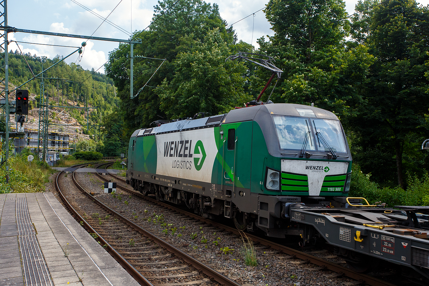 Die österreichische Weco Rail / Wenzel Logistics SIEMENS Vectron AC 1193 900 (91 81 1193 900-8 A-WENA) der Weco Rail GmbH, Wien (ex Walser Eisenbahn GmbH) fährt am 05 August 2025, mit einem KLV-Ganzzug der österreichischen Wenzel Logistics GmbH (Werndorf), durch den Bahnhof Kirchen/Sieg in Richtung Köln.

Die SIEMENS Vectron AC wurde 2022 Siemens in München-Allach unter der Fabriknummer 23014 gebaut und an die damalige WEG - Walser Eisenbahn GmbH geliefert. Im April 2023 wurde die Walser Eisenbahn GmbH in Weco Rail GmbH umfirmiert. Zudem gab man die Partnerschaft mit der Wenzel Logistics GmbH bekannt, die mit zwei eigenen Siemens Vectron Lokomotiven agiert.

Diese Vectron Lokomotive ist als AC – Lokomotive (Wechselstrom-Variante) mit 6.400 kW Leistung und für eine Höchstgeschwindigkeit von 200 km/h konzipiert. Sie wurde in der Vectron Variante AC B14 ausgeführt und hat so die Zulassungen für Deutschland, Österreich, Ungarn, Tschechien, Slowakei, Rumänien und Bulgarien (D / A / H / CZ / SK / RO / BG). So besitzt die Variante AC B14 folgende Zugsicherungssysteme:
ETCS BaseLine 3, sowie für 
Deutschland (PZB90 / LZB80 (CIR-ELKE I))
Österreich (ETCS Level 1 mit Euroloop, ETCS Level 2, PZB90 / LZB80)
Ungarn (ETCS Level 1, EVM (Mirel))
Tschechien und Slowakei (LS (Mirel))
Rumänien und Bulgarien (PZB90)

TECHNISCHE DATEN:
Spurweite: 1.435 mm (Normalspur)
Achsformel: Bo’Bo’
Länge über Puffer: 18.980 mm
Breite (über Handstangen): 3.012 mm
Höhe (Panto abgesenkt): 4.248 mm
Begrenzungslinie: UIC 505-1
Drehzapfenabstand:  9.500 mm
Achsabstand in Drehgestell:  3.000 mm
Raddurchmesser:  1.250 mm (neu) / 1.160 mm (abgenutzt)
Dienstgewicht: 87 t
Max. Radsatzlast: 21,8 t
Meterlast: 4.742 kg
Höchstgeschwindigkeit: 200 km/h 
Antriebsleistung: 6.400 kW (AC)
Anfahrzugkraft: 340 kN
Kleinster bef. Halbmesser: 140 m (Strecke) / 80 m (Depot)
Stromsysteme: 15kV/16,7Hz und 25kV/50Hz
Antriebsart: IGBT Stromrichter und Drehstrom Fahrmotore mit Ritzelhohlwellenantrieb
Bremsbauart: KE-GPR-E m Z, (D), ep. Dynamisches Bremssystem Elektrodynamische Hochleistungs-Rückspeisebremse
Leistung der dynamischen Bremse: 6.400 kW 
E-Bremskraft der dynamischen Bremse: 150 / 240 kN
