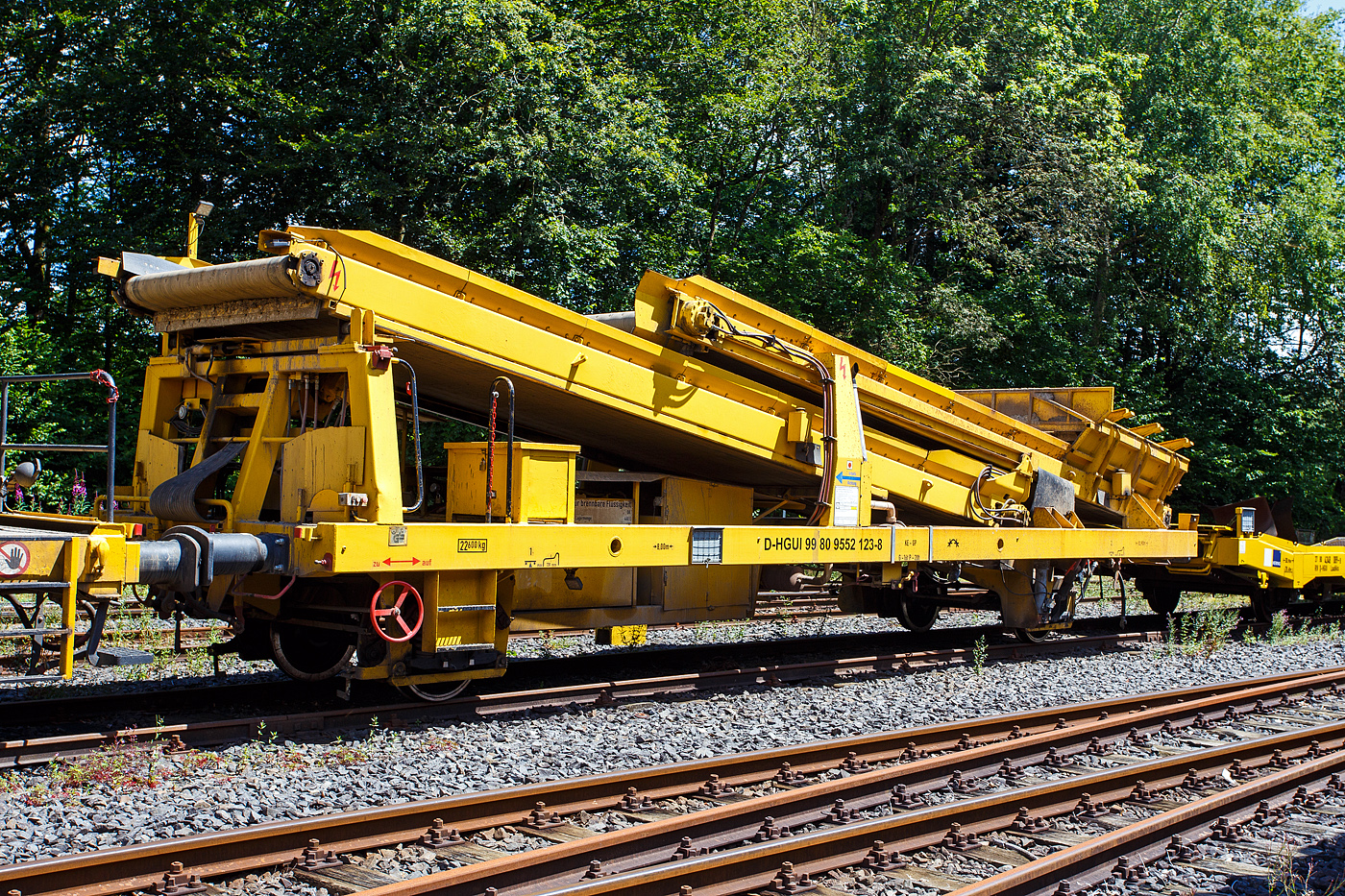 Die Plasser & Theurer Beladestation BLS 2000 (BLS 40 – 2000) der HERING Bahnbau (Burbach) Schweres Nebenfahrzeug Nr. D-HGUI 99 80 9552 123-8, ex 97 19 26 502 57-8 ist am 13.03.2023 auf dem Betriebshof der Westerwaldbahn (WEBA) auf der Bindweide bei Steinebach/Sieg abgestellt.

Die Beladestation wurde 1993 von Plasser & Theurer unter der Fabriknummer 2161 gebaut.

Die BLS 2000 ist ein zweiachsiges, gleisfahrbares Gerät. Die BLS 2000 kann unter spannungsführenden Fahrleitungen eingesetzt werden. Sie kann mit MFS 38, 40, 100, BSW 2000 und 6000 gekoppelt werden. Der Boden des Aufnahmebandes und des Übergabebandes ist als steuerbares Band mit einer Förderbreite von 1.920 mm ausgebildet. An der Baustelle angekommen, ist eine Aufrüstzeit von ca. 3 Minuten nötig. Der Aufnahmetrichter wird auf eine Höhe von max. 1,15 m über SOK abgesenkt und das Übergabeband wird ausgefahren. Hiernach können die Schüttgüter (alter Gleisschotter, Planum etc.) mittels Laderaupe, Radlader oder Bagger über die BLS in die MFS oder BSW verladen werden. Die Förderbänder werden hydraulisch angetrieben. Der Antrieb des Hydraulikaggregates erfolgt durch einen luftgekühlten Deutz Dieselmotor vom Typ F5L912 mit einer Leistung von 64 kW.

TECHNISCHE DATEN:
Achsanzahl: 2
Eigengewicht: 22.600 kg
Länge über Puffer: 12.900 mm
Achsabstand: 8.000 mm
Laufraddurchmesser: 730 mm (neu)
Höchstgeschwindigkeit: 100 km
Kleinster befahrbarer Gleisbogen: R 120 m
Bremse: KE-GP
Handbremse: Ja