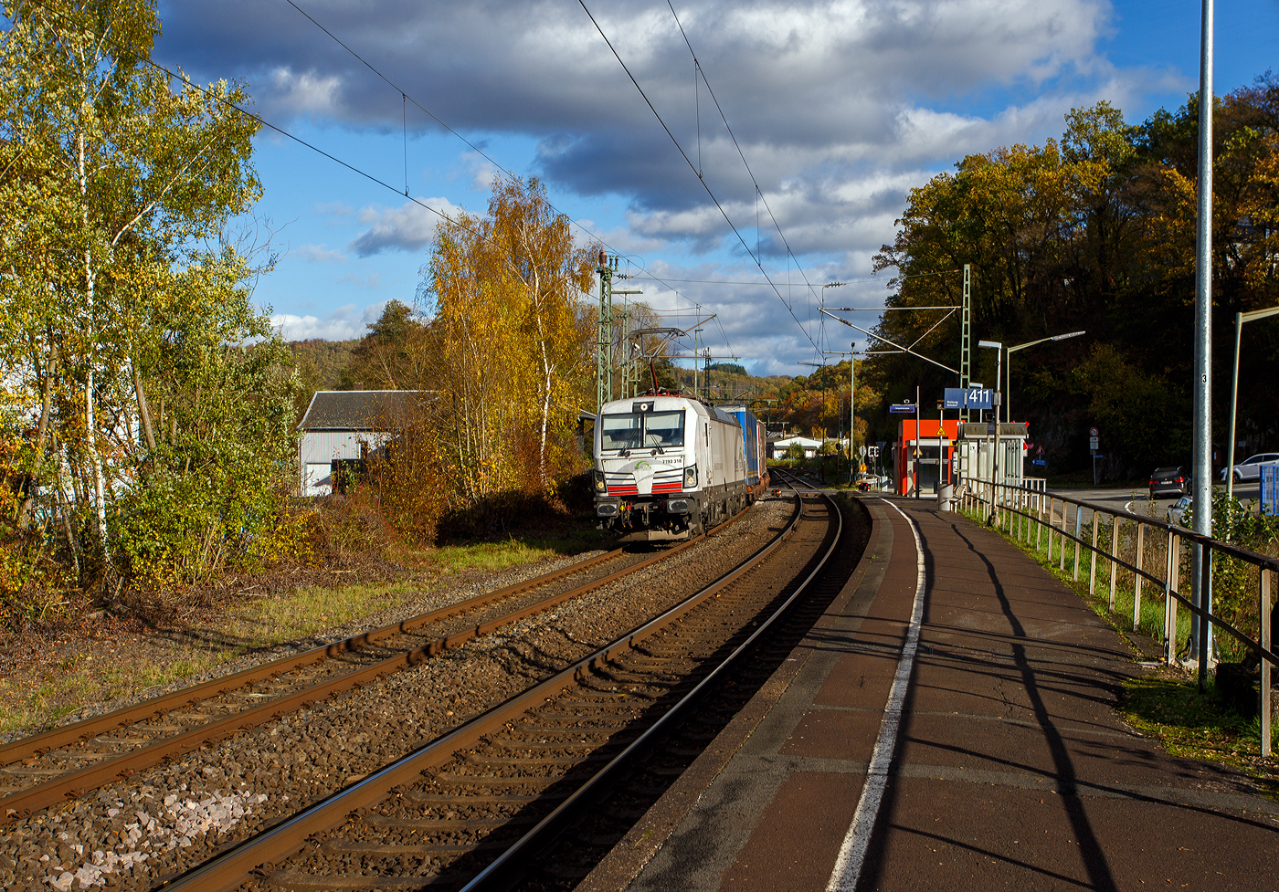 Die recht neue wei�e TXL 7193 318 „Connected to Nature“ (91 80 7193 318-1 D-TXL) der TXL - TX Logistik AG (Troisdorf) f�hrt am 30 Oktober 2025 mit einem KLV-Zug durch Scheuerfeld/Sieg in Richtung K�ln. Als Schlussl�ufer war am Zugschluss zudem die kalte, an die HSL Logistik GmbH vermietete, AKIEM 186 383-6.

Nochmals einen lieben Gru� an den netten Lokf�hrer zur�ck.

Die SIEMENS Vectron MS (X4E) wurde 2024 von Siemens Mobility in M�nchen-Allach unter der Fabriknummer 24282 gebaut und am 24.01.2025 an die TXL ausgeliefert. Die mit 6.400 kW konzipierte Mehrsystemlok ist in der Variante A22-11i ausgef�hrt und hat so die und hat so die Zulassungen und entspr. L�nderpakete f�r Deutschland, �sterreich, Schweiz, Italien und die Niederlande (D / A / CH / I / NL).

�ber TX Logistik AG
TX Logistik wurde 1999 als privates Eisenbahnverkehrsunternehmen gegr�ndet und bietet mit Verbindungen in elf L�ndern ein leistungsf�higes europ�isches Netzwerk. Das Unternehmen verf�gt �ber Tochtergesellschaften in der Schweiz, �sterreich, D�nemark und Schweden sowie eine lokale Pr�senz in Italien. In den Gesch�ftsbereichen Intermodal und Rail Freight entwickelt TX Logistik umfassende Schienenl�sungen f�r kontinentale und maritime Verkehre sowie ma�geschneiderte Konzepte f�r konventionelle Fracht. Mit 650 Mitarbeitern und 8,6 Milliarden gefahrenen Tonnenkilometern erwirtschaftete das Unternehmen 2021 einen Jahresumsatz von 253 Millionen Euro. Seit Januar 2017 geh�rt TX Logistik zu 100 Prozent der Mercitalia Logistics S.p.A., einer Tochtergesellschaft der FS - Ferrovie dello Stato Italiane. Mittlerweile geh�rt das Unternehmen mit zu den Gr��ten f�r den Schieneng�terverkehr in Europa.

Das Unternehmen bietet den ganzen Umfang an Schieneng�terverkehr, inklusive Containertransport und kombiniertem Verkehr an. Wichtigste Transportstrecken sind von den H�fen Hamburg, Bremerhaven, Rotterdam und Antwerpen nach S�ddeutschland, Schweiz, �sterreich und Italien.

TX Logistik setzt nun auf eigene Vectron Loks:
Anfang Oktober 2024 hat die TX Logistik AG ersten drei von 40 modernen Vectron-Lokomotiven des Herstellers Siemens Mobility aufs Gleis gesetzt, die das zur Mercitalia Logistics (FS Italiane Group) geh�rende Schienenlogistikunternehmen im Mai 2023 bestellt hatte. Die Erweiterung der Fahrzeugflotte ist f�r TX Logistik eine wichtige Voraussetzung, um im intermodalen und grenz�berschreitenden Schieneng�terverkehr weiter zu wachsen. Die neuen Lokomotiven werden vor allem auf dem Brenner- und dem Schweiz-Korridor eingesetzt, den strategisch wichtigen Nord-S�d-Achsen in Europa.

Beide Korridore sind stark frequentiert und stellen hohe Anforderungen an die eingesetzten Lokomotiven – von der Zugkraft �ber die Stabilit�t bis hin zur grenz�berschreitenden Systemkompatibilit�t. TX Logistik hat dazu die Maschinen mit verschiedenen L�nderpaketen bestellt. 20 Vectron erhalten das L�nderpaket f�r den Betrieb in Deutschland, �sterreich, Schweiz, Italien und den Niederlanden (D-A-CH-I-NL) und sollen bis Anfang 2025 �bergeben werden. Die Auslieferung der 20 Lokomotiven mit der Ausstattung f�r den deutsch-�sterreichisch-italienischen Korridor (D-A-I) soll bis zum Jahresende 2025 erfolgen.

Die Entscheidung f�r den Kauf der Vectron-Lokomotiven unterstreicht zugleich das Bestreben von TX Logistik, Schieneng�terverkehre als umweltfreundliche und effiziente Alternative zum Stra�entransport weiter voranzutreiben. Um dies zu unterstreichen und gleichzeitig f�r den Einstieg in den intermodalen Transport zu werben, hat die erste der drei Vectrons, die im Zughotel in Braunschweig �bergeben wurden, eine spezielle Lok-Beklebung mit dem Schriftzug „Start now (Nature). Driven by Green Passion“ erhalten.

Die neuen Loks bieten mit ihrer Flexibilit�t und Leistungsf�higkeit ideale technische Voraussetzungen, um den steigenden Anforderungen des europ�ischen G�terverkehrs gerecht zu werden. Mit der modernen Vectron-Flotte, so TX Logistik, sei man mittelfristig nun in der Lage, die Kapazit�ten auf dem Brenner- und dem Schweiz-Korridor deutlich zu erh�hen sowie die Effizienz und Zuverl�ssigkeit im Schieneng�terverkehr weiter zu verbessern.
