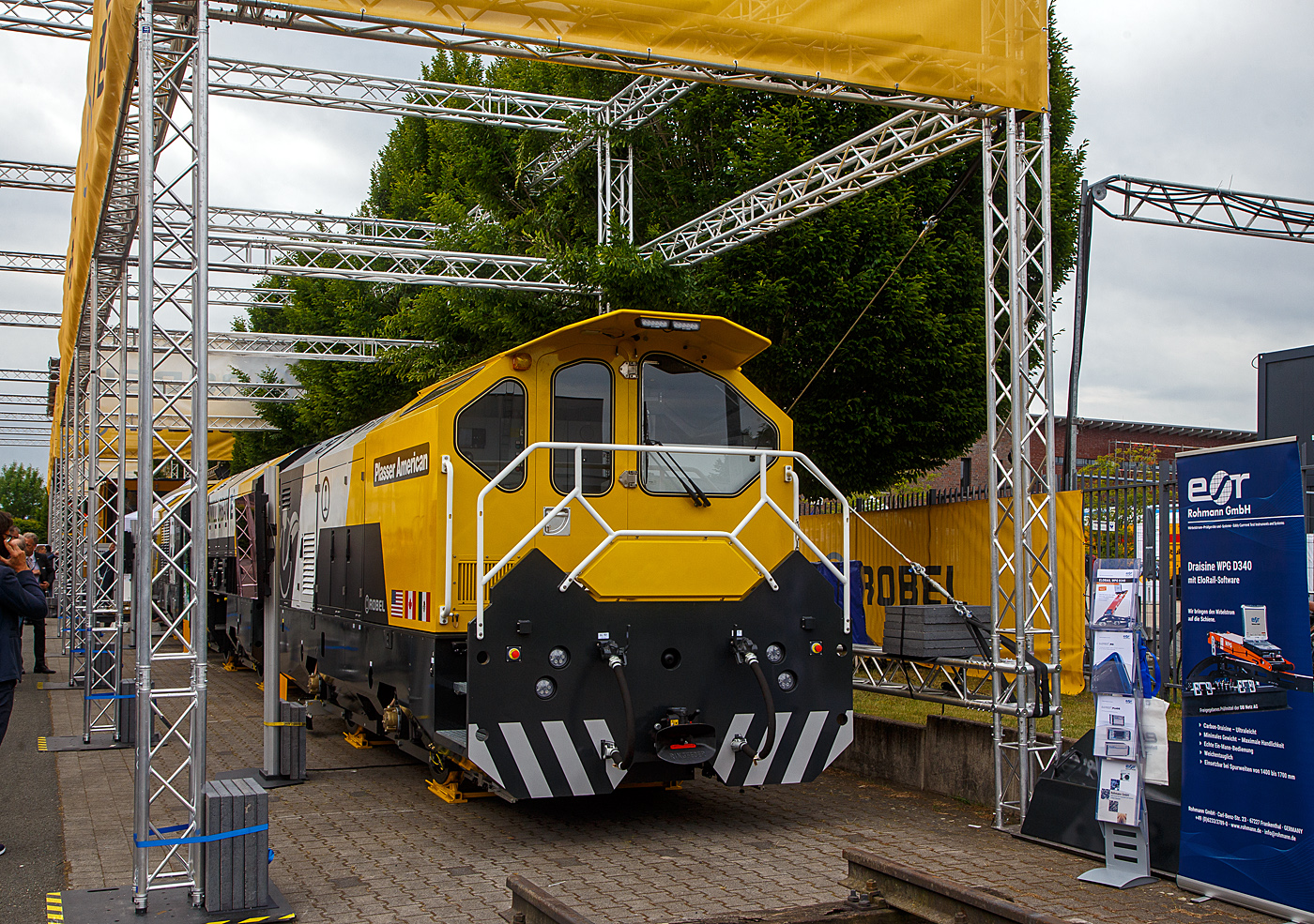 Die Robel Bahnbaumaschinen GmbH aus Freilassing (geh�rt zu Plasser & Theurer) pr�sentierte auf der 28. Internationale Ausstellung Fahrwegtechnik (iaf) in M�nster (hier am 31.05.2022) das dreiteilige Schienenbearbeitungssystem ROMILL Urban 3 E� f�r die Plasser American Corporation (PAC) mit Sitz in Chesapeake, Virginia. Die Lieferung soll im Sommer 2022 erfolgen. Das Schienenbearbeitungssystem ROMILL Urban E� ist ein gemeinsames Projekt von Robel, Schweerbau International GmbH & Co.KG (SBI) und Vogel & Pl�tscher GmbH & Co.KG, es ist die weltweit erste Hybrid-Fr�smaschine von Robel. Die Firmen Schweerbau und SBI geh�ren auch zur Robel Holding GmbH, ex Deutsche Plasser Holding GmbH.

Fahrzeugdesign, Antriebs -und Fr�stechnologien der Romill Urban E� wurden von SBI speziell f�r die U-Bahn Instandhaltung entwickelt. Die drei Einheiten sind f�r sehr kleine Lichtraumprofile, beispielsweise die der London Underground, ausgelegt und k�nnen somit in beinahe allen nordamerikanischen Tunneln eingesetzt werden. Der Hybrid-Antrieb, eine Kombination aus Batteriespeicher und Range-Extender �ber einen abgasreduzierten Dieselmotor, erm�glicht emissionsfreie Schienenbearbeitung. Der Hybridantrieb erm�glicht mit seiner Hochleistungsbatterie bis zu 3 Stunden emissionsfreien Betrieb (kein CO, CO2 oder NOx etc.). Dar�ber hinaus fungiert der integrierte Tier-4-F-Dieselmotor als Range Extender und bietet Schnellladef�higkeiten.

Romill Urban E� ist mit einer neuen, rein elektrischen Fr�stechnologie ausgestattet, die erstmals auch die Bearbeitung von Gleisen mit geringer Gleislagequalit�t erlaubt. Die Reprofilierung der Schiene erfolgt staub- und funkenfrei mit vollst�ndigem Recycling der Sp�ne. Zur Erzeugung einer l�rmoptimierten Schienenlauffl�che kommt zus�tzlich ein Hochgeschwindigkeits-Polierprozess zur Anwendung. Das revolution�re neue Schneidkopfdesign f�hrt zu einer l�ngeren Werkzeuglebensdauer und erm�glicht erweiterte Einsatzm�glichkeiten ohne Werkzeugwechsel. Die Maschine ist mit modernster Messtechnik ausgestattet, darunter Metallabtrag, Querprofil, L�ngsprofil und Wirbelstromsystem. Durch die modulare Konfiguration ist zur Leistungssteigerung 4-teilige Einheit m�glich.

Durch das kompakte Layout der Fr�smaschine passt sie die engsten U-Bahn-Tunnel. Sein ergonomisches dreiteiliges Maschinendesign erm�glicht eine schnelle De-/Remontage und einen einfachen LKW-Transport zwischen den Einsatzorten.

TECHNISCHE DATEN:
Fahrzeugl�nge: 23.000 mm
Breite: 2.350 mm
H�he: 2.850 mm
Anzahl der Achsen: 6 (3 Wagen mit je 2 Achen)
Gewicht: 77,5 t
Max. Achslast: 13,3 t
H�chstgeschwindigkeit bei Eigenfahrt: 60 km/h (37 mph)
Min. Kurvenradius im Fahrbetrieb: R 30 m (164 ft)
Min. Kurvenradius im Arbeitsbetrieb: R 50 m (99 ft)
Minimalradien f�r Bearbeitung: 50 m
Minimalradien f�r Fahrten: 50 m
Hauptmotor :Diesel eu stage V
Optionaler Antrieb: Akku
Vorschub: 300 – 1200 m/h
Abtrag je �berfahrt: 0,1 – 1,5 mm

Quellen: Robel, Plasser American