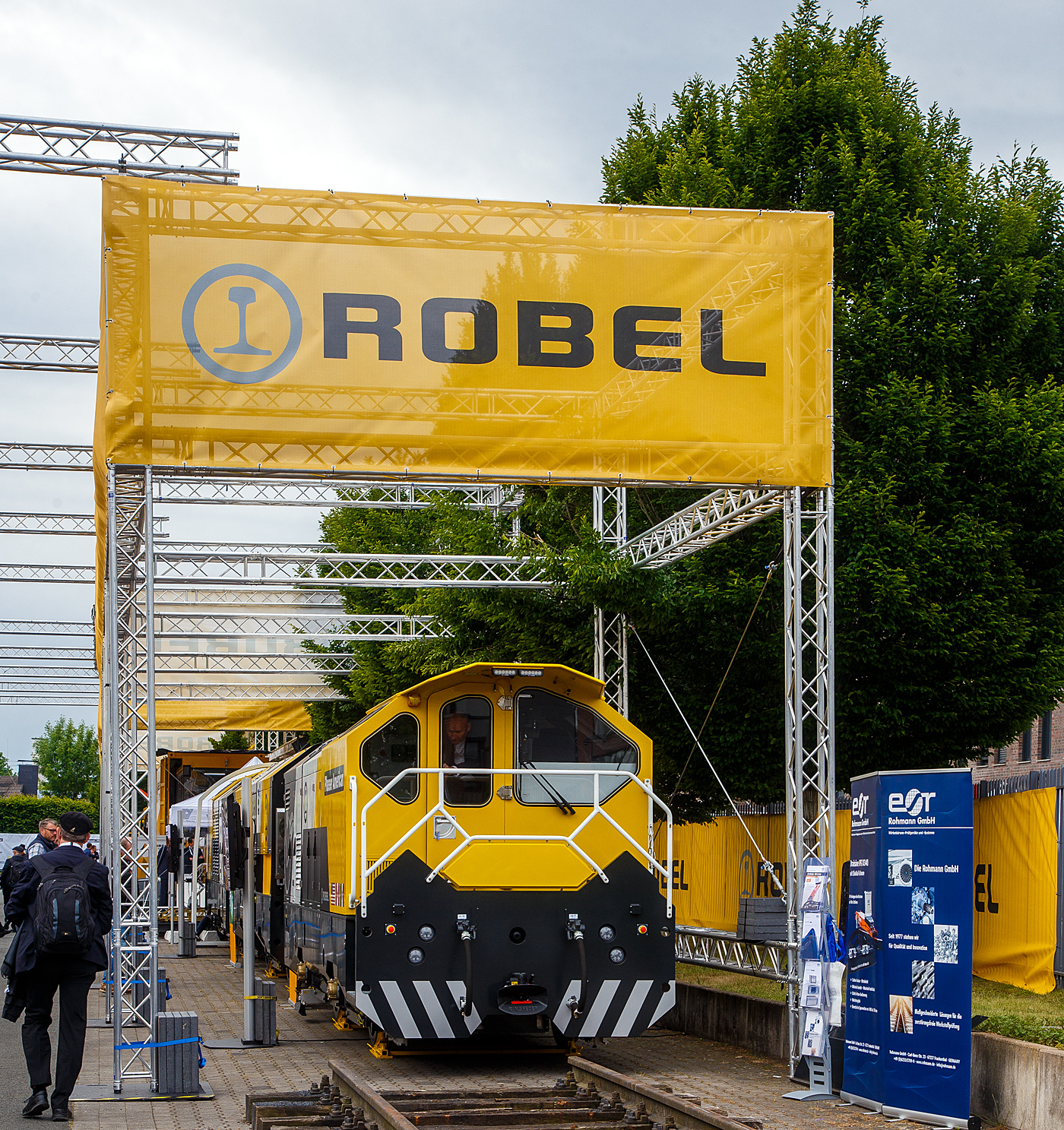 Die Robel Bahnbaumaschinen GmbH aus Freilassing (geh�rt zu Plasser & Theurer) pr�sentierte auf der 28. Internationale Ausstellung Fahrwegtechnik (iaf) in M�nster (hier am 31.05.2022) das dreiteilige Schienenbearbeitungssystem ROMILL Urban 3 E� f�r die Plasser American Corporation (PAC) mit Sitz in Chesapeake, Virginia. Die Lieferung soll im Sommer 2022 erfolgen. Das Schienenbearbeitungssystem ROMILL Urban E� ist ein gemeinsames Projekt von Robel, Schweerbau International GmbH & Co.KG (SBI) und Vogel & Pl�tscher GmbH & Co.KG, es ist die weltweit erste Hybrid-Fr�smaschine von Robel. Die Firmen Schweerbau und SBI geh�ren auch zur Robel Holding GmbH, ex Deutsche Plasser Holding GmbH.

Fahrzeugdesign, Antriebs -und Fr�stechnologien der Romill Urban E� wurden von SBI speziell f�r die U-Bahn Instandhaltung entwickelt. Die drei Einheiten sind f�r sehr kleine Lichtraumprofile, beispielsweise die der London Underground, ausgelegt und k�nnen somit in beinahe allen nordamerikanischen Tunneln eingesetzt werden. Der Hybrid-Antrieb, eine Kombination aus Batteriespeicher und Range-Extender �ber einen abgasreduzierten Dieselmotor, erm�glicht emissionsfreie Schienenbearbeitung. Der Hybridantrieb erm�glicht mit seiner Hochleistungsbatterie bis zu 3 Stunden emissionsfreien Betrieb (kein CO, CO2 oder NOx etc.). Dar�ber hinaus fungiert der integrierte Tier-4-F-Dieselmotor als Range Extender und bietet Schnellladef�higkeiten.

Romill Urban E� ist mit einer neuen, rein elektrischen Fr�stechnologie ausgestattet, die erstmals auch die Bearbeitung von Gleisen mit geringer Gleislagequalit�t erlaubt. Die Reprofilierung der Schiene erfolgt staub- und funkenfrei mit vollst�ndigem Recycling der Sp�ne. Zur Erzeugung einer l�rmoptimierten Schienenlauffl�che kommt zus�tzlich ein Hochgeschwindigkeits-Polierprozess zur Anwendung. Das revolution�re neue Schneidkopfdesign f�hrt zu einer l�ngeren Werkzeuglebensdauer und erm�glicht erweiterte Einsatzm�glichkeiten ohne Werkzeugwechsel. Die Maschine ist mit modernster Messtechnik ausgestattet, darunter Metallabtrag, Querprofil, L�ngsprofil und Wirbelstromsystem. Durch die modulare Konfiguration ist zur Leistungssteigerung 4-teilige Einheit m�glich.

Durch das kompakte Layout der Fr�smaschine passt sie die engsten U-Bahn-Tunnel. Sein ergonomisches dreiteiliges Maschinendesign erm�glicht eine schnelle De-/Remontage und einen einfachen LKW-Transport zwischen den Einsatzorten.

TECHNISCHE DATEN:
Fahrzeugl�nge: 23.000 mm
Breite: 2.350 mm
H�he: 2.850 mm
Anzahl der Achsen: 6 (3 Wagen mit je 2 Achen)
Gewicht: 77,5 t
Max. Achslast: 13,3 t
H�chstgeschwindigkeit bei Eigenfahrt: 60 km/h (37 mph)
Min. Kurvenradius im Fahrbetrieb: R 30 m (164 ft)
Min. Kurvenradius im Arbeitsbetrieb: R 50 m (99 ft)
Minimalradien f�r Bearbeitung: 50 m
Minimalradien f�r Fahrten: 50 m
Hauptmotor :Diesel eu stage V
Optionaler Antrieb: Akku
Vorschub: 300 – 1200 m/h
Abtrag je �berfahrt: 0,1 – 1,5 mm

Quellen: Robel, Plasser American