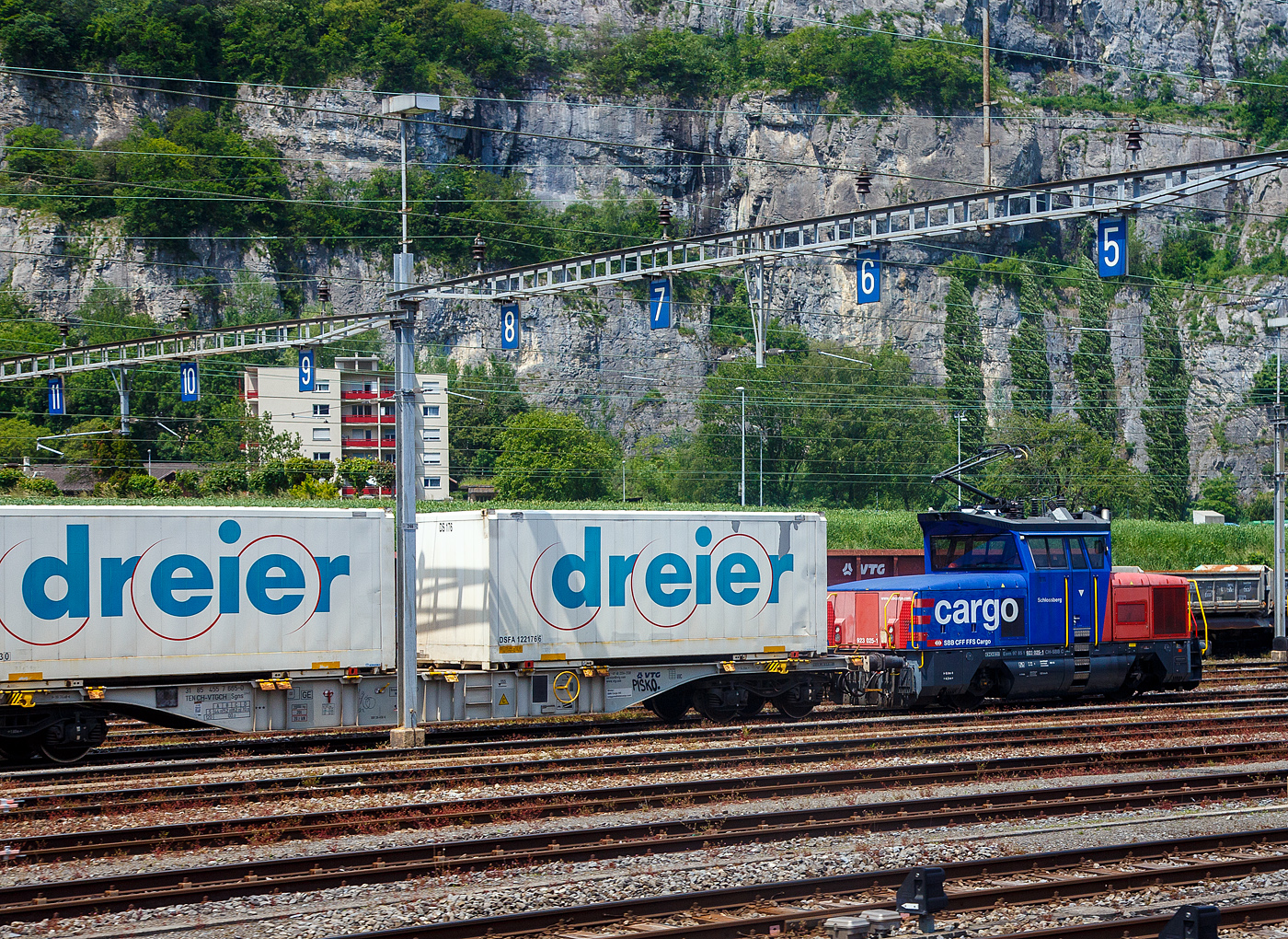 Die SBB Cargo Eem 923 025-1  Schlossberg  (Eem 97 85 1 923 025-1 CH-SBBC) am 28.05.2023 beim Bahnhof St-Maurice (aus dem Zug heraus aufgenommen). 

Die Zweikraft Lokomotive vom Typ  BUTLER  (Zweifrequenz-Hybridlokomotive) wurde 2013 von Stadler Winterthur unter der Fabriknummer L-11000/025 gebaut.

Die Eem 923 basiert zu einem großen Teil auf den bei der SBB im Personenverkehr in Betrieb befindlichen Stadler Zweifrequenz-Rangier-E-Lok Ee 922  BUTLER . Der Antrieb erfolgt über zwei Drehstrom-Asynchronmotoren mit Stromrichtern auf IGBT-Basis. Für die fahrdrahtunabhängige Energieerzeugung ist zudem ein dieselelektrischer Antrieb mit einem 336 kW starken Dieselmotor vorhanden.
