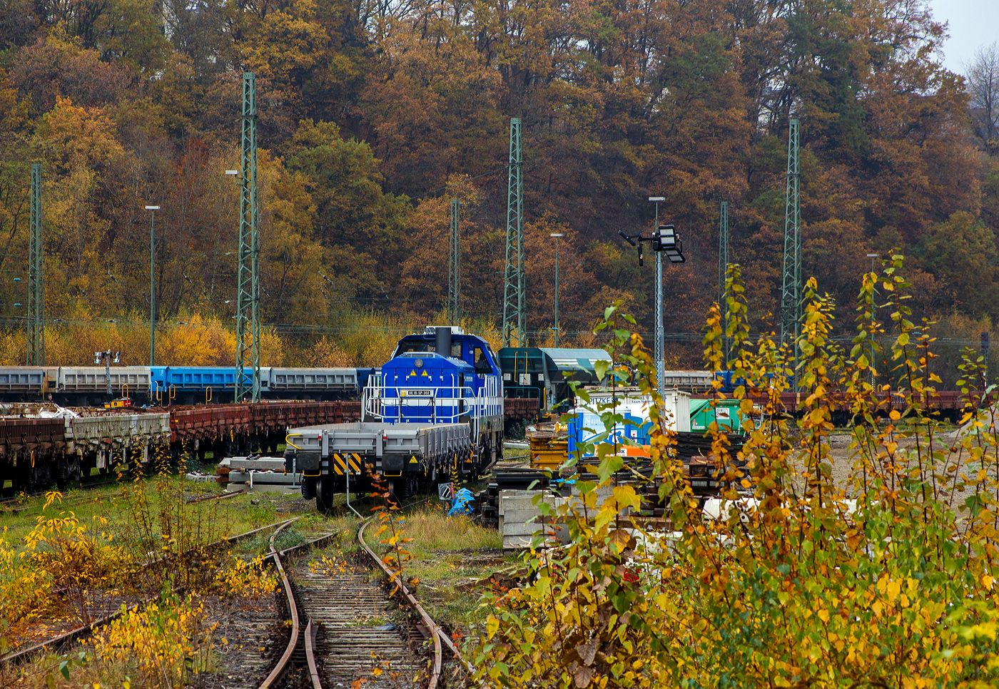 Die sehr neue SPITZKE DE18-SP-302 / 4185 302-1 (92 80 4185 302-1 D-SLG) eine dieselelektrische Vossloh DE 18 der SPITZKE SE steht am 08 November 2025 hinter einem Res-Wagen im Rbf Betzdorf/Sieg. 

Die DE18 wurde 2025 von der Vossloh Rolling Stock GmbH in Kiel unter der Fabriknummer 5502655 gebaut und am 14.08.2025 an die SPITZKE SE, Großbeeren ausgeliefert (Tag der Überführung).

Die Diesellokomotive der Baureihe DE 18 ist insbesondere für den schweren Rangier- und Streckenbetrieb mit hoher Zugkraft geeignet. Sie gilt als aktuell leistungsstärkste Mittelführerhauslokomotive auf dem europäischen Markt. Die DE 18 ist für den Rangierbetrieb mit einer Funkfernsteuerung ausgerüstet und ist für bis zu drei Loks mehrfachtraktionsfähig. Durch Energiesparmodus und Start-Stopp-System reduziert sie Schadstoffausstoß und spart Treibstoff ein, zudem besitzt sie einen Rußpartikelfilter. Zusätzlich lässt sich der Kraftstoffverbrauch durch ein effizientes Motormanagement und einer Begrenzung der Motorleistung, wenn nicht die Maximalleistung benötigt wird, reduzieren. Der 1.800 kW starke MTU Dieselmotor wird durch ein Batteriepaket ergänzt, das einen bis zu einstündigen emissionsfreien Rangierbetrieb gewährleistet und Fahrten durch Null-Emissions-Bereiche etwa in Tunneln, Werkhallen oder Bahnhöfen, ermöglicht.

Die Lok hat eine Anfahrzugkraft von 300 kN und eine Dauerzugkraft von 230 kN bei 24.2 km/h. Höchstgeschwindigkeit beträgt 120 km/h, die kleinste Dauerfahrgeschwindigkeit 3 km/h,
