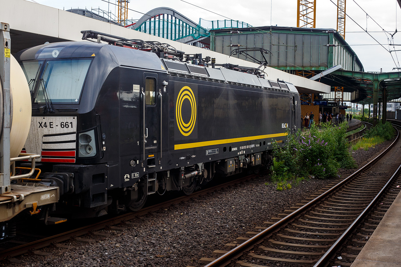 Die Siemens Vectron MS X4 E - 661 bzw. 193 661-6 (91 80 6193 661-6 D-DISPO) der BRCE - Beacon Rail Capital Europe (München) fährt am 24 Juni 2025 mit einem KLV-Zug durch den Hauptbahnhof Duisburg in Richtung Düsseldorf.

Die Multisystemlokomotive Siemens Vectron MS (160 km/h - 6.4 MW) wurde 2017 von Siemens in München-Allach unter der Fabriknummer 22237 gebaut. Sie wurde in der Variante A09 (Zulassungen für D / A / I) ausgeführt. Im Jahr 2022 erfolgte bei Siemens in München-Allach der Umbau in die Variante A22 und hat so die Zulassung für Deutschland, Österreich, die Schweiz, Italien und die Niederlande (D / A / CH / I / NL). So besitzt die Variante MS A22 folgende Zugsicherungssysteme: ETCS BaseLine 3, sowie für Deutschland (PZB90 / LZB80 (CIR-ELKE I)), für Österreich (ETCS Level 1 mit Euroloop, ETCS Level 2, PZB90 / LZB80), für fie Schweiz (ETCS Level 2, ZUB262ct, INTEGRA), für Italien (SCMT) und die Niederlande (ETCS Level 1, ETCS Level 2, ATB-EGvv).

Die Lok wurde an die MRCE - Mitsui Rail Capital Europe GmbH in München ausgeliefert, seit September 2023 hat die Beacon Rail Metro Finance B.V. die Mitsui Rail Capital Europe B.V. (Amsterdam) und somit auch die Mitsui Rail Capital Europe GmbH im München übernommen, so firmiert sie nun als Beacon Rail Capital Europe GmbH, München (BRCE / DISPO).
