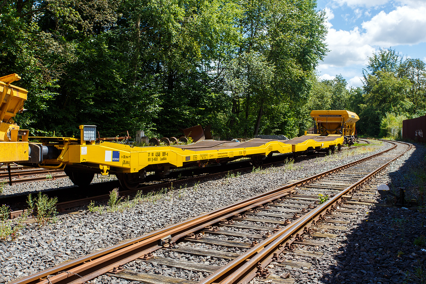 Die vierachsige (2 x 2 achsige) lange Flachwageneinheit mit abgesenktem Fu�boden (hier ohne Radvorlegern) 27 80 4348 089-8 D-HGUI, der Gattung Laadkks (TWA 850 RV), der HERING Bahnbau GmbH, Burbach ist am 07 Juli 2024 auf dem Betriebshof der Westerwaldbahn (WEBA) auf der Bindweide bei Steinebach/Sieg abgestellt. 

Der Wagen wurde 1991 von dem sizilianischen Hersteller Keller S.p.A. in Palermo (I) gebaut und an die TRANSWAGGON GmbH (Hamburg) geliefert. So war er bis zum Verkauf (202_) an die HERING Bahnbau als 27 80 434 8 089-8 D-TWA unterwegs.

TECHNISCHE DATEN:
Gattung: Laadkks (TWA 850 RV)
Spurweite: 1.435 mm
Anzahl der Achsen: 4 (2 x 2)
L�nge �ber Puffer : 30.980 mm
Ladel�nge : 29.740 mm
Ladebreite : 3.100 mm
Fu�bodenh�he �ber SOK: 850 / 1.000 mm
H�chstgeschwindigkeit: 100 km/h / 120 km/h (leer)
Eigengewicht: 28.100 kg
Nutzlast: 43,9 t ab Streckenklasse B
Achsabst�nde: 9.000 mm / 6.480 mm / 9.000 mm
Kleinster befahrb. Gleisbogenhalbmesser: 75 m
Bremse: Freno 2x KE-GP-A (LL)
Bremssohle: IB 116
Handbremse: Ja
Intern. Verwendungsf�higkeit: RIV