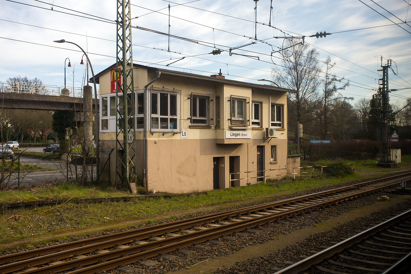 Ein Blick aus dem Zug auf das elektromechanische Weichenw�rter Stellwerk Lingen (Ems) S�d „Ls“ am 14 M�rz 2024. Das aktive Stellwerk ist in der Bauform VES 1912 (E43) mit Farbscheiben�berwachung.