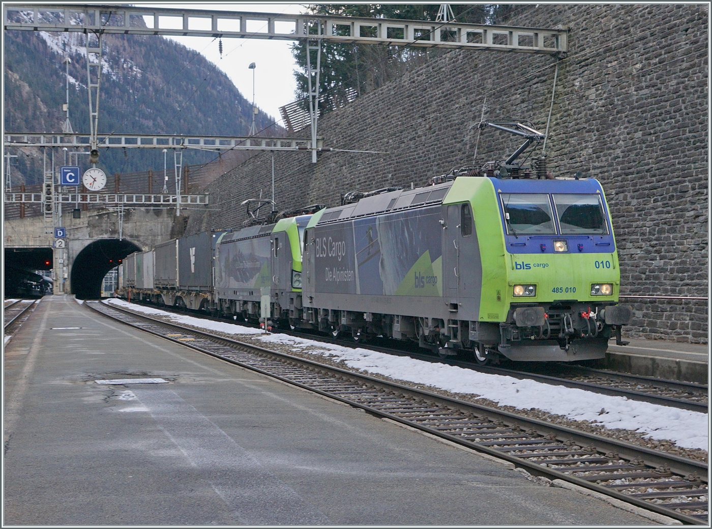 Ein Güterzug mit der BLS Re 485 010 und einer BLS Re 475 fährt durch den Bahnhof von Goppenstein. 

3. Jan. 2024