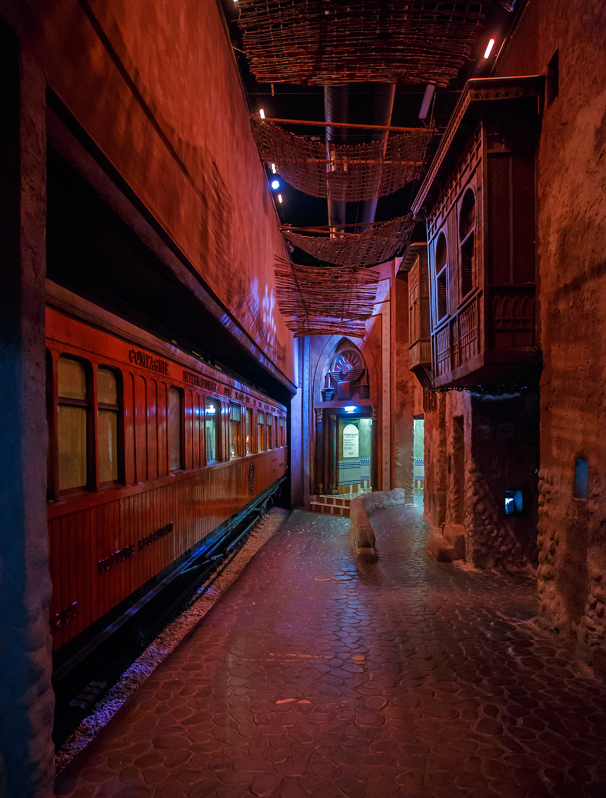 Ein Hauch von Orient in den Niederladen, der Teakholz-Speisewagen WR 2287 ehemals der CIWL - Compagnie Internationale des Wagons Lits et des Grands Express Européens, am 24 Juni 2025 im Het Spoorwegmuseum (bis 2005 NSM - Nederlands Spoorwegmuseum / Niederländischen Eisenbahnmuseum) in Utrecht im ehemaligen Bahnhof Maliebaan.

Der Wagen wurde 1911 von Rába Magyar Waggon- és Gépgyár Reszvénytársaság in Győr, Ungarn (Raab Ungarische Waggon- und Maschinenfabrik Aktiengesellschaft) für die Compagnie Internationale des Wagons Lits et des Grands Express Européens (CIWL) gebaut. 

Am 4. Dezember 1876 gründete George Nagelmackers in Belgien die „Compagnie Internationale des Wagons Lits“. Der Name wurde später zu „et des Grands Express Européens“ erweitert. Das Unternehmen konzentrierte sich hauptsächlich auf Luxusreisezüge auf internationalen Strecken. Die von der CIWL in Auftrag gegebenen Schlafwagen ermöglichten Nachtfahrten und sparten so deutlich Zeit auf langen Strecken. Dank der Speisewagen konnten zudem die bis dahin üblichen Essenspausen entfallen, was eine weitere Zeitersparnis bedeutete.

Außergewöhnliche Sorgfalt wurde auf das Rollmaterial gelegt, wie dieser luxuriöse Teakholzwagen WR 2287 im Museum beweist. Dieser Speisewagen ist einer von vielen luxuriösen Holzwaggons Teakholzwagen, die Wagon Lits für seine internationalen Züge bauen ließ, darunter auch für den bekannten Orient-Express (Paris – Istanbul). Der Wagen war hauptsächlich in Südosteuropa im Einsatz und wahrscheinlich auch im berühmten Orient-Express im Einsatz. 

Der vierachsige Speisewagen verfügt über eine Zentralheizung mit Kohleofen, eine Küche mit Kohleofen, Kühlschränken und verschiedenen Küchenutensilien. Der zweigeteilte Speisesaal bietet 36 Sitzplätze (freistehende und ledergepolsterte Stühle) an jeweils sechs Tischen für 2 bzw. 4 Personen.

Als das Eisenbahnmuseum 1953 eröffnete, bestand der Bedarf, der Öffentlichkeit Erfrischungen anzubieten. Ein hölzerner Speisewagen wurde in Erwägung gezogen, war jedoch in Westeuropa nicht mehr erhältlich. In Ungarn wurde jedoch dieser ehemalige CIWL- Teakholzwagen entdeckt, der noch immer als Dienst-und Arbeitswagen im Einsatz war. Die Werkstatt der Ungarischen Eisenbahn in Dunakeszi, damals noch hinter dem Eisernen Vorhang, restaurierte diesen Waggon vollständig und vorbildlich. Der Wagen kam 1977 ins Eisenbahnmuseum nach Utrecht. Ursprünglich sollte der Wagen vom Museum als Restaurant genutzt werden, aber nach der Renovierung in Ungarn erhielt er einen prominenten Platz in der Sammlung.

In einem solcher Wagen dieser Serie (CIWL 2419 D) wurde 1918 der Waffenstillstand des Ersten Weltkriegs unterzeichnet, 1940 die Kapitulation Frankreichs vor den Deutschen. 

TECHNISCHE DATEN:
Baujahr: 1911
Spurweite: 1.435 mm (Normalspur)
Achsen: 4 (in 2 Drehgestellen)
Achsfolge:	2'2'
Länge über Puffer: 20.400 mm
Sitzplätze: 36
