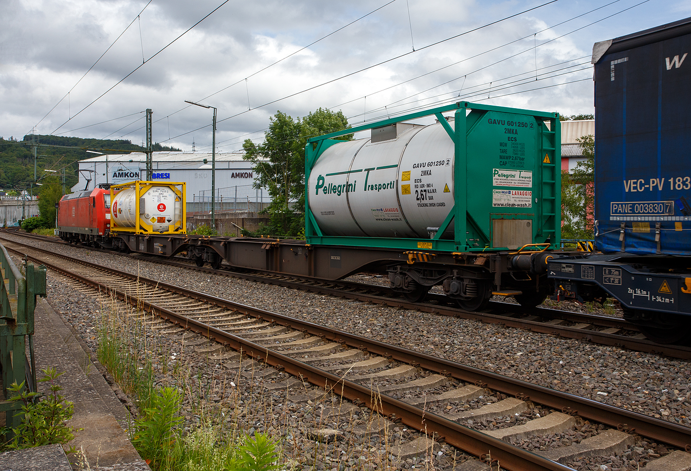 Ein langer sechsachsige Drehgestell-Gelenk-Containertragwagen-Einheit (6- achsiger Containertragwagen-Einheit), 33 80 496 1 024-3 D-Kombi, der Gattung Sggmrss (104‘), der Kombiverkehr GmbH & Co KG (Frankfurt am Main), hier beladen mit 2 Tank-Containern, am 21 Juni 2024 im Zugverband (hinter der DB 185 154-2) bei der Zugdurchfahrt in Niederschelden (Siegstrecke). 

Der Wagen wurde 2002 vom polnischen Hersteller Europejskie Konsorcjum Kolejowe WAGON Sp. z o.o. (heute Polski Tabor Szynowy – Wagon Sp. z o.o.) in Ostrów Wielkopolski (PL) gebaut. Er hat die EBA-Nr.r 01 L16 A025.

Jeder Wagen kann mit 4 Wechselbehältern / Containern (7,15 m, 7,45 m und 7,82 m), beladen werden, mit einem Gesamtladegewicht von 105 t. Dadurch wird in der Zugkomposition Ladelänge und Gewicht eingespart.

TECHNISCHE DATEN (laut Anschriften):
Spurweite: 1.435 mm
Anzahl der Achsen: 6 in drei Drehgestellen
Länge über Puffer: 33.480 mm
Drehzapfenabstände: 2 x 13.970 mm
Eigengewicht: 29.740 kg
Max. Zuladung bei Lastgrenze S: 104,0 t (ab Streckenklasse D)
Max. Zuladung bei Lastgrenze SS: 90,0 t (ab Streckenklasse C)
Max. Geschwindigkeit: 100 km/h (Lastgrenze SS oder leer 120 km/h)
Kleinster bef. Gleisbogenradius: R 75 m (Einzelwagen) / R 150 (Zugverband)
Bremse: 2 x MH-GP-A (K)
Bremssohle: Jurid 816M
Verwendungsfähigkeit: RIV

Die Kombiverkehr GmbH & Co KG ist ein logistisches Dienstleistungsunternehmen und ein Eisenbahnverkehrsunternehmen mit Sitz in Frankfurt am Main (Deutschland). Gegründet wurde die Gesellschaft am 11. Februar 1969 durch 56 Straßentransporteure und Kraftwagenspediteure. Bis zur Beteiligung der DB Mobility Logistics AG mit 50 % im Jahr 2002 hielten die Spediteure 100 % der Kommanditanteile. Im März 2023 waren 225 nationale und internationale Speditionen sowie die DB Cargo Kommanditisten.

Von der Kombiverkehr GmbH & Co KG wird ein Netz für den Kombinierten Verkehr Schiene-Straße in Europa entwickelt, organisiert und vermarktet. Als ergänzende Leistungen werden u. a. der Aufbau und Betrieb von Umschlaganlagen und die Entwicklung und Unterhaltung von Spezialwaggons erbracht. Kombiverkehr ist seit November 1999 als öffentliches Eisenbahnverkehrsunternehmen zugelassen und kann Trassenleistungen direkt bei den Netzbetreibern einkaufen und Eigentraktionen durchführen. Kombiverkehr ist auch an vielen Terminals beteiligt.
