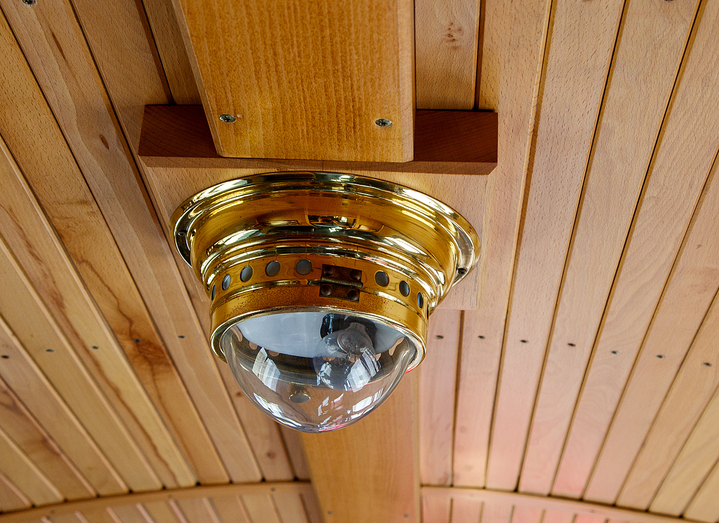 Eine alte Lampe mit Glühbirne im Innenraum des schmalspurigen (900 mm) vierachsige 2.Klasse Personenwagen mit offenen Plattformen, MBB 990-310 (ex DR 990-310), der Gattung KB4i, Mecklenburgische Bäderbahn Molli GmbH & Co., hier am 15 Mai 2022 im Bahnhof Kühlungsborn West.