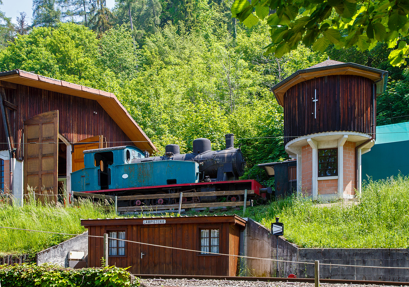 Eine Spanierin in der Schweiz - Die 1.000 mm G 3/5 Tenderlokomotive N° 23 der ursprünglichen Lokalbahn von Olot nach Girona (Tren d’Olot), in Katalonien (Spanien), seit 1971 bei der Museumsbahn Blonay–Chamby hier am 27.05.2023 im Museum Chaulin.

Die Lok (vom Typ 131T) wurde 1926 bei La Maquinista Terrestre y Marítima in Barcelona unter der Fabriknummer 282 gebaut. Die 56 km lange Bahnstrecke war 1892 bis 1969 in Betrieb, und ist heute wohl ein Bahntrassenradweg.

rovenienz: Olot-Girona-Eisenbahn, in Katalonien, Spanien
Der Bau der 55 km langen Strecke Olot-Girona in Katalonien begann 1892. Sie wurde nach und nach in Betrieb genommen und am 14. November 1911 auf ihrer gesamten Länge eingeweiht. An jeder Station erwartet eine große Menschenmenge die Eröffnung Konvoi, sehr spät nach einer glücklicherweise harmlosen Entgleisung, da der Mechaniker die Leistungsfähigkeit seiner Maschine demonstrieren wollte.

Der ursprüngliche Lokomotivpark englischer Bauart der Olot-Girona-Bahn wurde 1911 durch belgische Maschinen ergänzt. Mitte der zwanziger Jahre war eine Modernisierung dieses Parks unumgänglich. Zu dieser Zeit war die Elektrifizierung auf den Nebenbahnen in Spanien nicht üblich, daher erwarb das Unternehmen 1926 vier neue Dampflokomotiven, diesmal spanischer Bauart, darunter hier die Nr. 23. Die angepasste symmetrische Anordnung (3 Antriebsachsen, an jedem Ende von einer Bissel flankiert) sorgt für eine hervorragende Spurtreue sowohl vorwärts als auch rückwärts und verkürzt die Fahrzeiten erheblich. Der großzügig dimensionierte Führerstand bietet dem Fahrpersonal für eine Lokomotive mit Meterspur einen ungewöhnlichen Komfort, der angesichts der langen zurückgelegten Distanzen sehr zu schätzen ist.

Dank ihres großen Kessels und der Ausstattung mit Überhitzung bewältigen diese modernen, sparsamen und leistungsstarken Maschinen den Großteil des Verkehrs, was dazu führte, dass ältere Maschinen aus dem Verkehr gezogen wurden. In den 1930er und 1940er Jahren war die Strecke aufgrund des im Land herrschenden Bürgerkriegs häufig Ziel von Angriffen, insbesondere am 16. Mai 1946, als eine kriminelle Hand einen Konvoi in „Pas dels Gegants“ entgleiste, dabei war die Lokomotive Nr. 23. Sechzig Menschen wurden verletzt. Da die Maschine keinen allzu großen Schaden erlitten hatte, wurde sie in einem für die damaligen Verhältnisse recht spektakulären Einsatz geborgen und anschließend wieder in Betrieb genommen.

Durch die Anschaffung von Dieseltriebwagen im Jahr 1959 wurden Dampfloks auf die Traktion von Güterzügen verwiesen, bis die Strecke am 15. Juli 1969 stillgelegt wurde. Das ansprechende Aussehen und die technischen Eigenschaften dieser Lokomotiven erregten dann die Aufmerksamkeit der Verantwortlichen von der Blonay-Chamby im Juli 1971 ging die Lok zur BC.

Die Lok hat  ein Gewicht von 31 t, eine Leistung von 350 PS und eine Höchstgeschwindigkeit von 35 km/h.