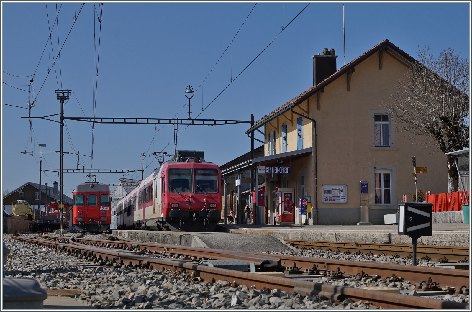Gleich vorne weg: Das Bild entstand auf dem wieder geöffneten Bahnübergang. (Siehe auch Geoposition). Zum Bild selbst: in Sentier Orient begegnet der TRAVYS RBDe 560 384-0 (RBDe 560 DO TR 94 85 7560 384-0 CH-TVYS)  Lac de Brenet  dem hier für einige Stunden abgestellten  Schülerzug  bestehend aus TRAVYS RBDe 567 174 (94 85 7567 174-8)  Fleurier , dem B 536 (B 50 85 2035 536-5 CH-TVYS) und dem ABt 375 (ABt 50 85 80 33 325-7), der infolge des in Le Brassus angekommen Güterzuges keinen Platz mehr fand. 
24. März 2022 