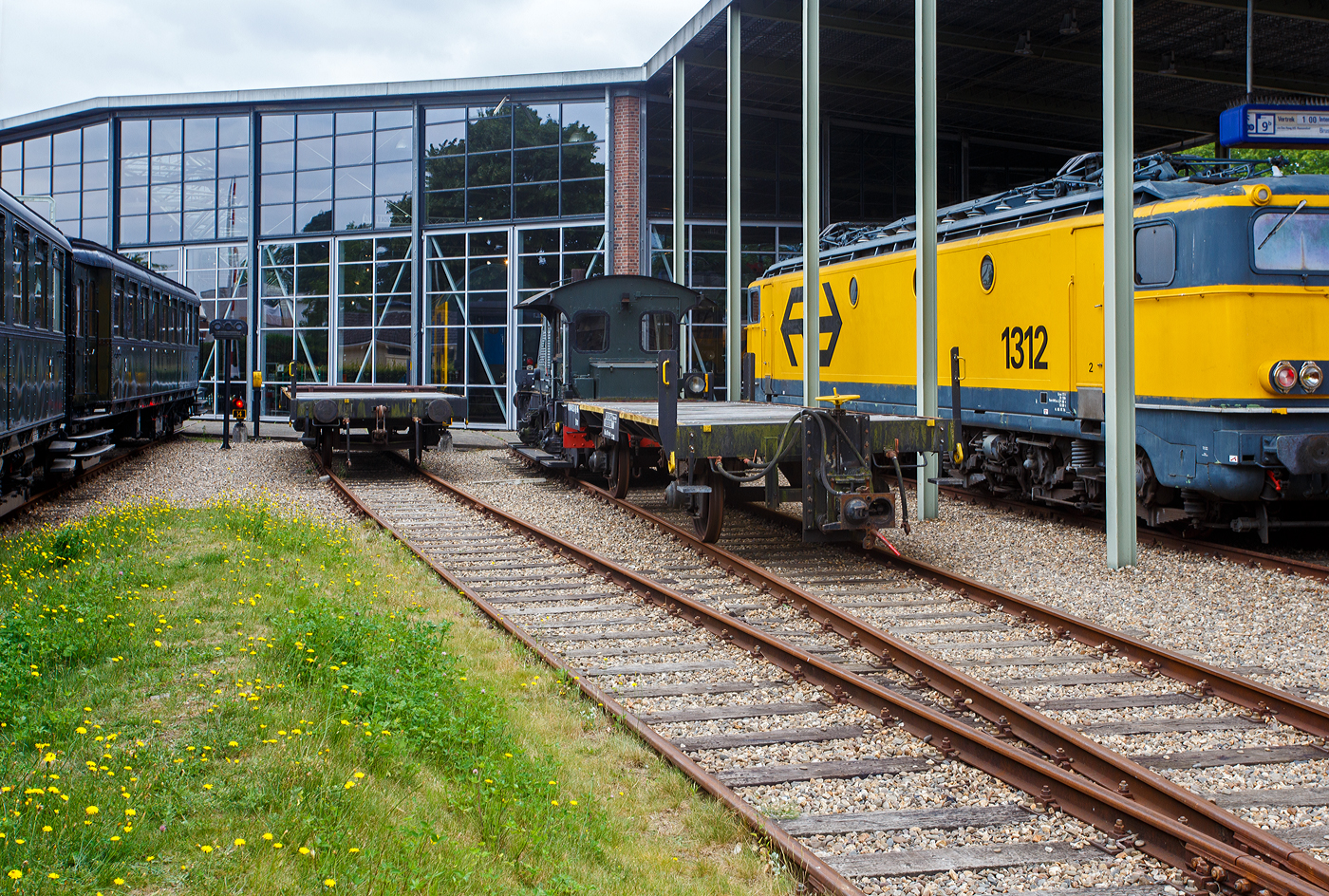 Hinter der ex NS Sik 311 der zweiachsige Kupplungswagen (Koppelwagen) ex 40 84 9441 532-1 NL-RFF (Rotterdam Rail Feeding), ex 30 84 9820 501-9 NL-NS, ex NS 61844, der Gattung U741, am 24 Juni 2025 im Het Spoorwegmuseum (bis 2005 NSM - Nederlands Spoorwegmuseum / Niederl�ndischen Eisenbahnmuseum) in Utrecht im ehemaligen Bahnhof Maliebaan. Links daneben steht noch der Kupplungswagen 40 84 944 1 974-5.

Diese Adapter- oder Kupplungswagen sind n�tig, wenn man mit einer Lok mit Puffern und Schraubkupplung Triebwagen und -z�ge mit Scharfenberger-Kupplung rangieren oder abschleppen muss. 

Nach dem Umbau (ca. 1970) aus Flachwagen erhielt der Wagen an einem Wagenende eine h�henverstellbaren Scharfenberger-Kupplung und wurde in Hoek van Holland stationiert. Die Kupplungsh�he ist von 610 mm �ber Schienenoberkante bis 1.070 mm verstellbar, sodass er an alle Stromlinienfahrzeuge gekoppelt werden kann. Am anderen Wagenende behielt er die Puffer und Schraubkupplung, so kann er an diese Seite an eine Lok gekuppelt werden. An der Unterseite des Fahrgestells sind au�erdem l�ngs 15 Stahlschienen f�r zus�tzlichen Ballast angebracht. An drei Ecken wurden Rangiertritte und Eckpfosten mit Griffen angebracht.

Auff�llig ist (nach meiner Sichtung), dass der Wagen keine eigenen Bremsen hat. Er hat aber durchg�ngige Bremsluftleitungen, so dass die abzuschleppende Triebz�ge von der Lok mit der erforderlichen Druckluft f�r die Bremsen versorgt werden konnten. Wobei hier der Sik 311 (Rangierlok) wohl nicht eine ausreichende Luftmenge liefern kann, da der rein mechanisch gebremst wird und keinen Kompressor besitzt.

TECHNISCHE DATEN:
Spurweite: 1.435 mm (Normalspur)
Anzahl der Achsen: 2
L�nge �ber Puffer: 9.550 mm
Achsabstand: 5.000 mm
Ladefl�che: 
Leergewicht: 9.000 kg
Max. Zuladung: 0 kg (Nur als Kupplungswagen verwendbar)
H�chstgeschwindigkeit: 80 km/h
