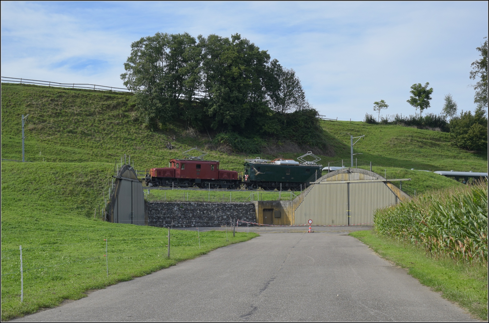 Historische Seethalbahn in Aktion.

Der Museumszug mit Seetalkrokodil De 6/6 15301, A 3/5 10217 und den Seetalwagen fährt oberhalb der Bunkerhangare des Flugplatz Emmen vorbei. September 2024.