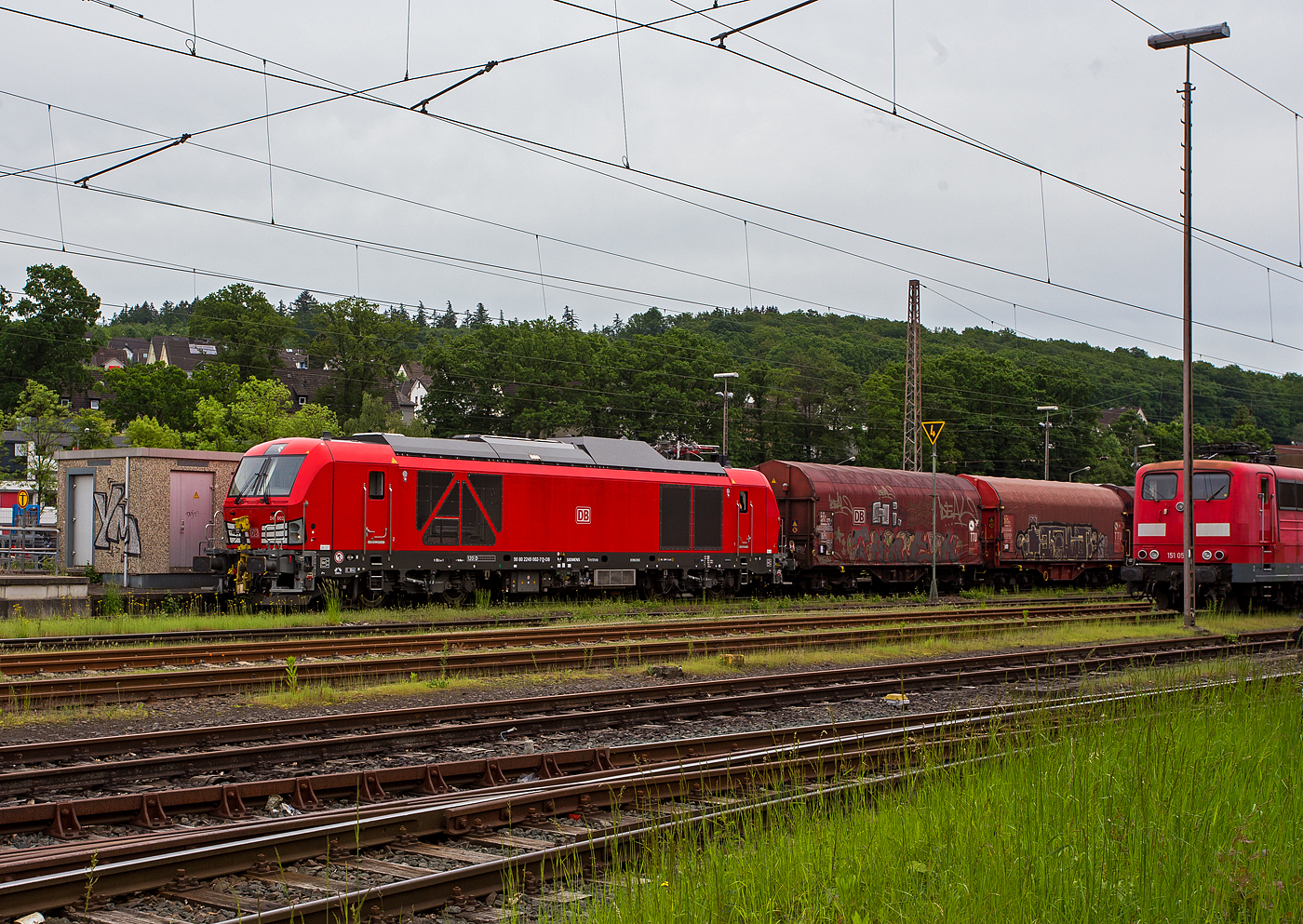 Ich war schon �berrascht dass ich diese neuen Zweikraftlokomotiven „Siemens Vectron Dual Mode light“ (BR 249) der DB Cargo AG in Kreuztal nun schon sehen konnte und dann auch gleich 3 St�ck. Am 21 Mai 2024 waren hier die 249 002-7 (0 80 2249 002-7 D-DB), die 249 003-5 (90 80 2249 003-5 D-DB) und die 249 006-8 (90 80 2249 006-8 D-DB).

Hier dr�ckt die 249 002-7 (0 80 2249 002-7 D-DB) der DB Cargo AG einen G�terzug im Last-Mile-Modus (mit Dieselantrieb) vom Abstellbereich beim Bahnhof Kreuztal zum Rangierbahnhof (Rbf Kreuztal). Da hier Oberleitungen vorhanden sind, w�re eigentlich der Last-Mile-Modus (Dieselantrieb) nicht n�tig, aber vermutlich war es ein Test- bzw. Schulungsbetrieb.

Die Vectron Dual Mode light 249 002-7 der Baureihe 249 wurden 2022 von Siemens Mobility GmbH in M�nchen-Allach unter der Fabriknummer 23060 gebaut. Die Lok war von Ende Mai 2022 erst durch Siemens Mobility GmbH, als 90 80 2249 002-7 D-SDEHC registriert/eingestellt. Erst nach der Abnahme durch die DB Cargo und den Verkauf an diese im M�rz 2024 wurde sie als 90 80 2249 003-5 D-DB eingestellt. Die Loks der Baureihe 249 haben die Zulassung f�r Deutschland und eine H�chstgeschwindigkeit von 120 km/h.

Diese Lokomotivbaureihe wird man bald auf deutschen Gleisen wohl oft sehen k�nnen. Denn die DB Cargo erneuert seine Rangier- und Strecken-Lokflotte und beschafft neue Zweikraftlokomotiven der BR 249, als Ersatz f�r die �lteren Diesellokomotiven der Reihe 294 (V 90). Es wurde Rahmenvertrag mit dem Hersteller Siemens Mobility �ber bis zu 400 Fahrzeuge, die einem Investitionsvolumen von deutlich �ber einer Milliarde Euro entsprechen, angeschlossen. Geliefert werden Lokomotiven vom Typ Vectron Dual Mode light mit spezifischen Anpassungen f�r das von DB Cargo geplante Einsatzspektrum. 
Zun�chst bestellt die DB Cargo 150 Loks der Baureihe 249. Diese DB Loks sind aber stark modifiziert, so betr�gt bei ihnen die Achslast maximal 21 t (statt 22,5 t). Sie besitzen in den F�hrerst�nden jeweils einen zus�tzlichen Seitenfahrschalter sowie ein Schwanenhalsmikrofon. Weitere Unterschiede sind die Ausr�stung mit Rangierkupplungen Rk900, Rangiertritten neben den Puffern, zus�tzlichen �berwachungskameras zur �berwachung des Raumes zwischen den Lokomotiven und Warnleuchten f�r den Betrieb mit Funkfernsteuerung.

Die Loks der Baureihe 249 (Vectron Dual Mode light) besitzen gegen�ber der BR 248 einem kleineren Dieselmotor von Cummins (QST 30-L) mit einer Leistung von 950 kW (anstatt des MTU 16V 4000 R84 mit 2.400 kW Leistung). Allein durch den kleineren Motor wurden ca. 5,5 t Gewicht eingespart.  So ist die speziell f�r die Anforderungen von DB Cargo optimierte „Vectron Dual Mode light“ imehrere Tonnen leichter als herk�mmliche Modelle und kann so auch auf Nebenstrecken und Gleisanschl�ssen mit geringerer Traglast eingesetzt werden. Diese Eigenschaften machen sie besonders geeignet f�r den Einzelwagenverkehr, der durch die Reduzierung des Lokwechsels schneller und effizienter wird-

TECHNISCHE DATEN der Vectron Dual Mode light (BR 249)
Einsatzbereich: G�terverkehr und Zugbildung
Spurweite: 1.435 mm (Normalspur)
Achsformel: Bo'Bo'
L�nge �ber Puffer: 20 510 mm
Drehzapfenabstand: 10.800 mm
Achsabstand im Drehgestell: 2.700 mm
Breite: 3.020mm
H�he:  4.220 mm
Raddurchmesser : 1.100 mm (neu) / 1.020 mm (abgenutzt)
Gewicht:  84 t (bei vollen Vorr�ten)
Achslast: 21 t
Spannungssysteme (bei E-Betrieb): 15 kV, 16,7 Hz
Dieselmotor: Gedrosselten  V12-Zylinder -Viertakt-Dieselmotor mit Turboaufladung und Ladeluftk�hlung, vom Typ Cummins QST 30-L
Dieselmotorleistung an der Kurbelwelle (gedrosselt): 950 kW (1.291 PS)
max. Dieselmotorleistung (Kw): 1.119 kW (1.521 PS)
Motorhubraum 30,5 Liter (Bohrung 140 mm x Hub 165 mm)
Dieselmotor Nenndrehzahl: 2.100 U/min
Dieselmotor Motorgewicht (trocken): 3.555 kg
Max. Leistung am Rad E-Antrieb: 2.210 kW  (3.005 PS)
Max. Leistung am Rad Dieselbetrieb: 750 kW (1.020 PS) / max. 926 kW m�glich
H�chstgeschwindigkeit:120 km/h
Antriebsart: elektrisch oder dieselelektrisch
Kraft�bertragung :Teilabgefederter Antrieb (Ritzelhohlwellenantrieb)
Kraftstoffbeh�lter Nutzvolumen: 1.500 Liter
Anfahrzugskraft:  300 kN
Elektrische Bremskraft: 150 kN
Elektrische Bremsleistung (am Rad): E-Betrieb 2.210 kW / Dieselbetrieb 1.000 kW
Doppeltraktion: �ber WTB �BB mit typgleichen Fahrzeugen 
Zugsicherung: PZB / f�r ETCS vorbereitet
