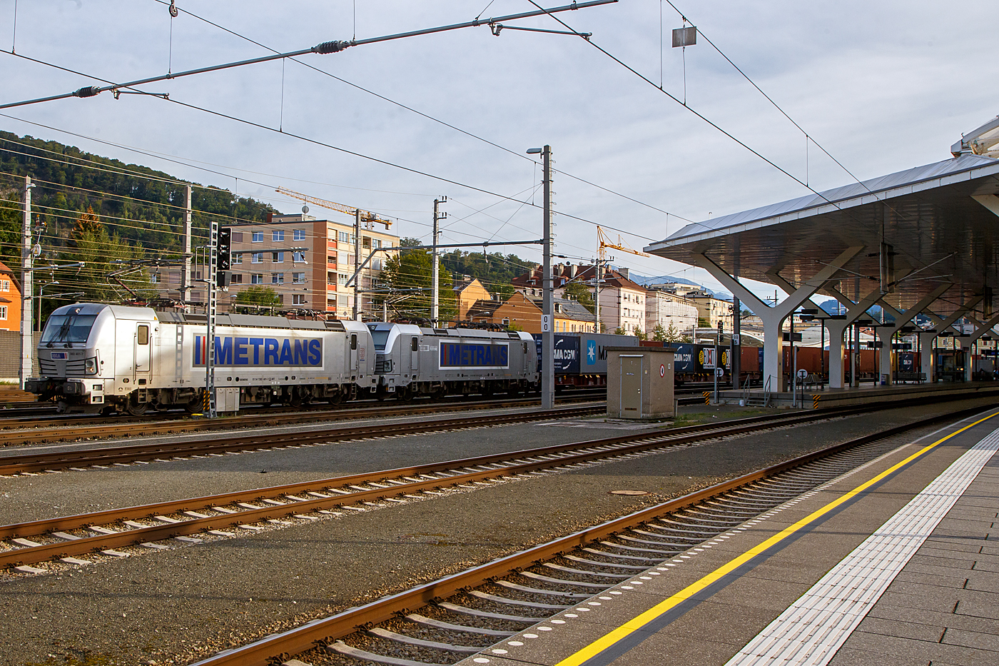 In Doppeltraktion fahren die 383 401-7 (91 54 7383 401-7 CZ-MT) und die 383 407-4 (91 54 7383 407-4 CZ-MT), zwei Siemens Vectron MS der METRANS Rail s.r.o. (Prag / Praha), mit einem Containerzug am 12.09.2022 durch den Hbf Salzburg in Richtung Osten. Die METRANS gibt es schon über 30 Jahren, sie ist ein 100 %-iges Tochterunternehmen der Hamburger Hafen und Logistik AG (HHLA).

Die beiden Siemens Vectron MS (Vectron X4 A01) wurden 2019 von Siemens Mobilitiy in München-Allach gebaut und an die METRANS geliefert. Die 401 unter der Fabriknummer 22688 und die 407 unter der Fabriknummer 22695. Sie sind in der Vectron MS Version A01und haben so die Zulassungen und Zugbeeinflussungssysteme für Tschechien, Deutschland, Österreich, Slowakei, Ungarn und Polen (CZ, D, A, SK, H, PL). Die neuen Lokomotiven für Metrans erreichen eine Höchstleistung von 6,4 MW und eine Spitzengeschwindigkeit von 160 km/h. 

Zukünftige Aufrüstungen für den Einsatz in Bulgarien, Kroatien, den Niederlanden, Rumänien, Serbien und Slowenien sind möglich. 