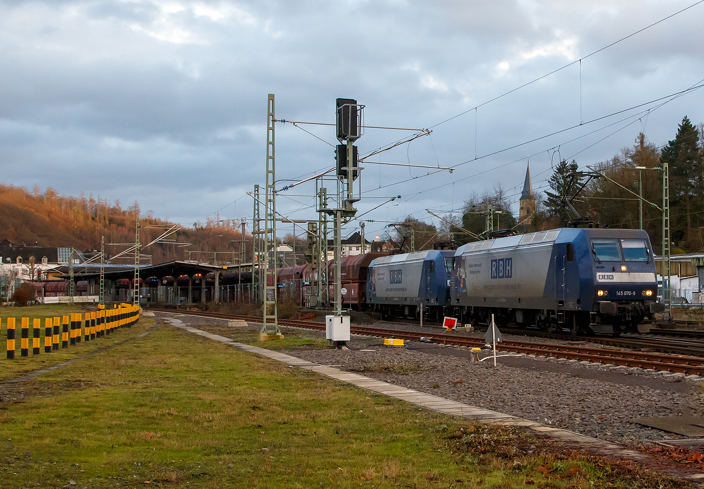 In Doppeltraktion fahren die von der DB Cargo an die RBH Logistics GmbH vermieteten 145 070-9 / RBH 229 (91 80 6145 070-9 D-DB) und die 145 055-0 / RBH 234 (91 80 6145 055-0 D-DB) am 11.01.2023 mit einem Kohlenzug (vierachsige offene Schüttgutwagen mit schlagartiger Schwerkraftentladung und hydraulischem Klappenverschlusssystem der Gattung Falns) in dem Rbf Betzdorf (Sieg). Die Einfahrt in den Rbf war nötig um einen schnelleren Güterzug sowie den RE 9 Überholfahrten zu ermöglichen (durch zulassen). 

Die beiden TRAXX F140 AC wurde 2000 von ADtranz (ABB Daimler-Benz Transportation GmbH) in Kassel unter Fabriknummern 33397 (145 070-9) und 33378 (145 055-0) gebaut und an die DB Cargo AG geliefert. Seit 2016 sind beide an die DB Cargo AG Tochter RBH Logistics GmbH in Gladbeck vermietet und sind auch als diese lackiert. 

Die RBH ist die Nachfolgegesellschaft von Werks-, Zechen- und Hafenbahnen im Raum der Bergwerksdirektion Recklinghausen. Durch die verschiedenen Firmenzusammenschlüsse und -aufteilungen ergab sich seit 1913 eine wechselvolle Geschichte. Das heute als Teil des Firmennamens genutzte Akronym RBH stand einige Jahre für die RAG-Bahn- und Hafenbetriebe und wurde beim Verkauf von dieser an die Railion Deutschland im Jahr 2005 beibehalten. Nach damaliger Angabe des neuen Eigentümers stehen die Buchstaben R, B und H nun für die Kernkompetenzen des Unternehmens: Eisenbahnverkehr (Rail), Binnenschifffahrt (Barge) und Hafenumschlag (Harbour).