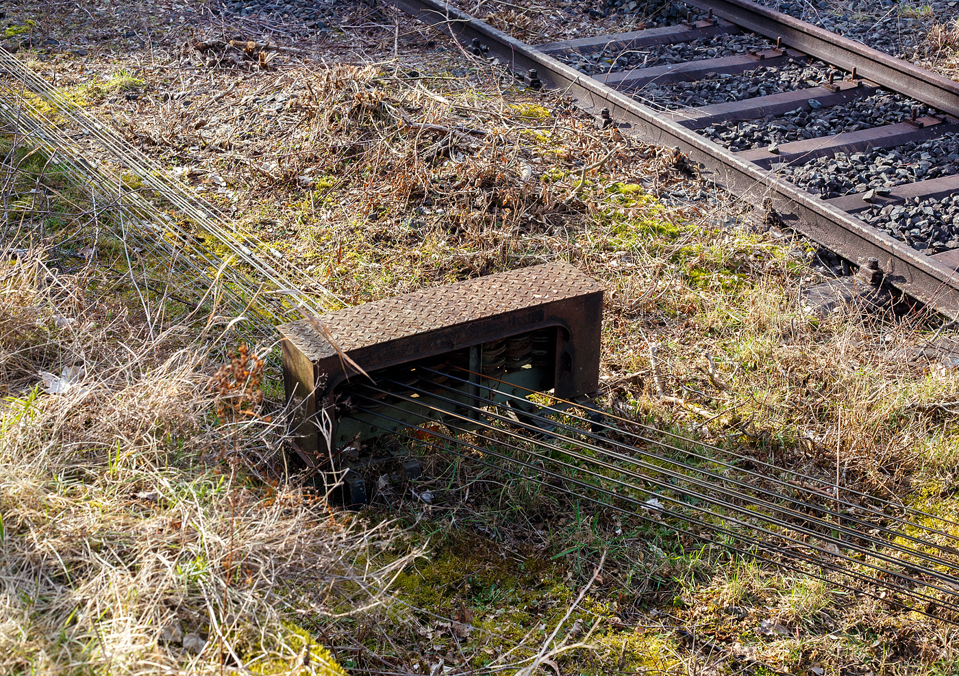 In Herdorf gibt es immer noch nach wie vor die beiden mechanischen. Stellwerke (Herdorf Fahrdienstleiter Hf und Herdorf Ost Ho). Von diesen werden die Weichen, Gleissperren und Signale die über Seilzüge betätigt werden. Die Seilzüge müssen wie hier, über solche Seilzugumlenkböcke (Stationen) mit den entsprechenden Umlenkrollen, umgelenkt werden.
Herdorf den 21.02.2025 nahe dem Stellwerk Ho
