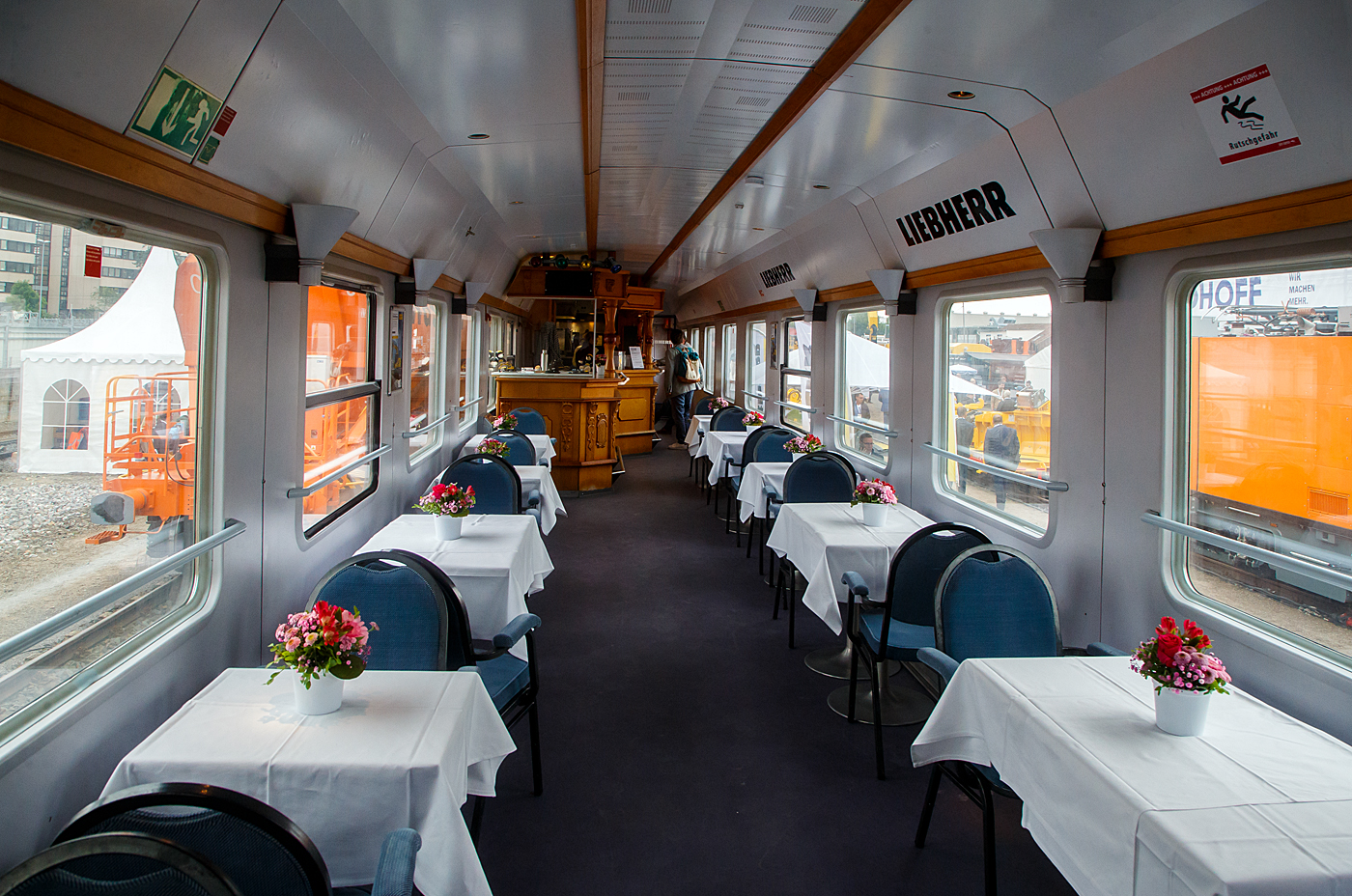 Innenansicht des Speise- und Barwagen der Bauart UIC-X (DB) D-EURO 56 80 89-90 010-0 [P] der Gattung WGm 038 der Euro-Express Sonderzüge GmbH & Co. KG, hier am 30 Mai 2022 vermietet an die Fa. LIEBHERR für die Bewirtung auf der 28. Internationale Ausstellung Fahrwegtechnik 2022 (iaf) in Münster. 

Der Großraumwagen der Bauart UIC-X (DB) wurde 1968 von O&K in Berlin als 2. Klasse Schnellzugwagen DB 51 80 50-80 043-3 Bcm 243 für die Deutsche Bundesbahn geliefert. Im Jahr 1984 erfolgte beim PFA Weiden (Partner für Fahrzeugausstattung GmbH) der Umbau zum WGm 038.8 (DB 61 80 09-90 010-0), 1996 ging er an die Euro-Express.