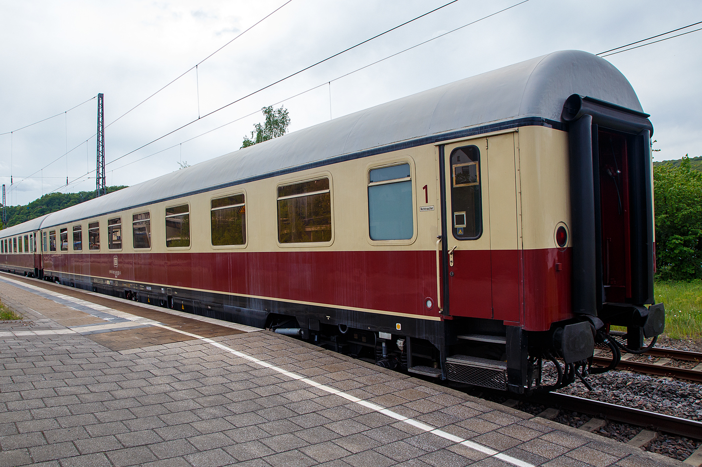 Klimatisierter 1. Klasse TEE Abteilwagen der Bauart Helvetia, D-DB 61 80 19-95 029-3 der Gattung Avmz 111.2, vom DB Museum Koblenz am 28.04.2018, im Zugverband von einen TEE Sonderzug (zum Dampfspektakel 2018) Koblenz – Trier, im Bahnhof Bullay DB.

Der Wagen wurde 1971 von Waggonfabrik Wegmann & Co. in Kassel gebaut und als D-DB 61 80 19-70 029-2 Avmz 111 an die Deutschen Bundesbahn geliefert. Ab 1977 wurde er zum 61 80 19-90 029-8 Avmz 111.1, und 1983 wurde er zum D-DB 61 80 19-95 029-3 Avmz 111.2.

Zum Jahresfahrplan 1965 wurden weitere F-Z�ge aufgewertet und in TEE-Z�ge umgewandelt (z. B. „Blauer Enzian“). Der TEE „Helvetia“ wurde von Triebz�gen der Baureihe VT 11.5 auf einen lokbespannte Wagenz�ge umgestellt. Daf�r mussten weitere Wagen angeschafft werden.
Bei den TEE -Wagen handelt es sich um eine Serie von Personenwagen der Deutschen Bundesbahn (DB) aus Erste-Klasse-Wagen, die aus den erfolgreichen UIC-X-Wagen der DB weiter entwickelt wurde.

Vorgesehen waren reine Erste-Klasse-Wagen in mehreren Bauarten. Die durch Gummiw�lste gesch�tzten Wagen�berg�nge waren nach neuen UIC-Anforderungen aber nunmehr durch zweifl�gelige Schiebet�ren gesichert. Jedoch waren die neuen Wagen klimatisiert. Der Bereich unterhalb des Wagenbodens wurde durch eine Sch�rze �hnlich den Sch�rzenwagen gesch�tzt.

Bei den Drehgestellen kam wie bei den m-Wagen die Bauart Minden-Deutz zum Einsatz, die aber f�r h�here Geschwindigkeiten ausgelegt wurden. Die Wagen sind mit selbstnachstellenden Scheibenbremsen und einer Magnetschienenbremse ausger�stet, so konnte die H�chstgeschwindigkeit auf 200 km/h erh�ht werden.

TECHNISCHE DATEN:
L�nge �ber Puffer: 26.400 mm
Wagenkastenl�nge: 26.100 mm
Wagenkastenbreite: 2.825 mm
H�he �ber Schienenoberkante: 4.050 mm
Drehzapfenabstand: 19.000 mm
Achsstand im Drehgestell: 2.500 mm
Drehgestellbauart: Minden-Deutz 367
Leergewicht: 44 t
H�chstgeschwindigkeit: 200 km/h
Sitzpl�tze (in der ersten Klasse): 54
Abteile: 9
Toiletten: 2
Heizungsbauart: Klimae
Energieversorgung: Zentrale Energieversorgung aus der Zugsammelschiene
Batterien: 24 V, 385 Ah
Bremsbauart: KE-GPR-Mg (D) [ep]
Zulassungen: D, A und CH (RIC)
Umgebaut aus: Avmz 111.1
