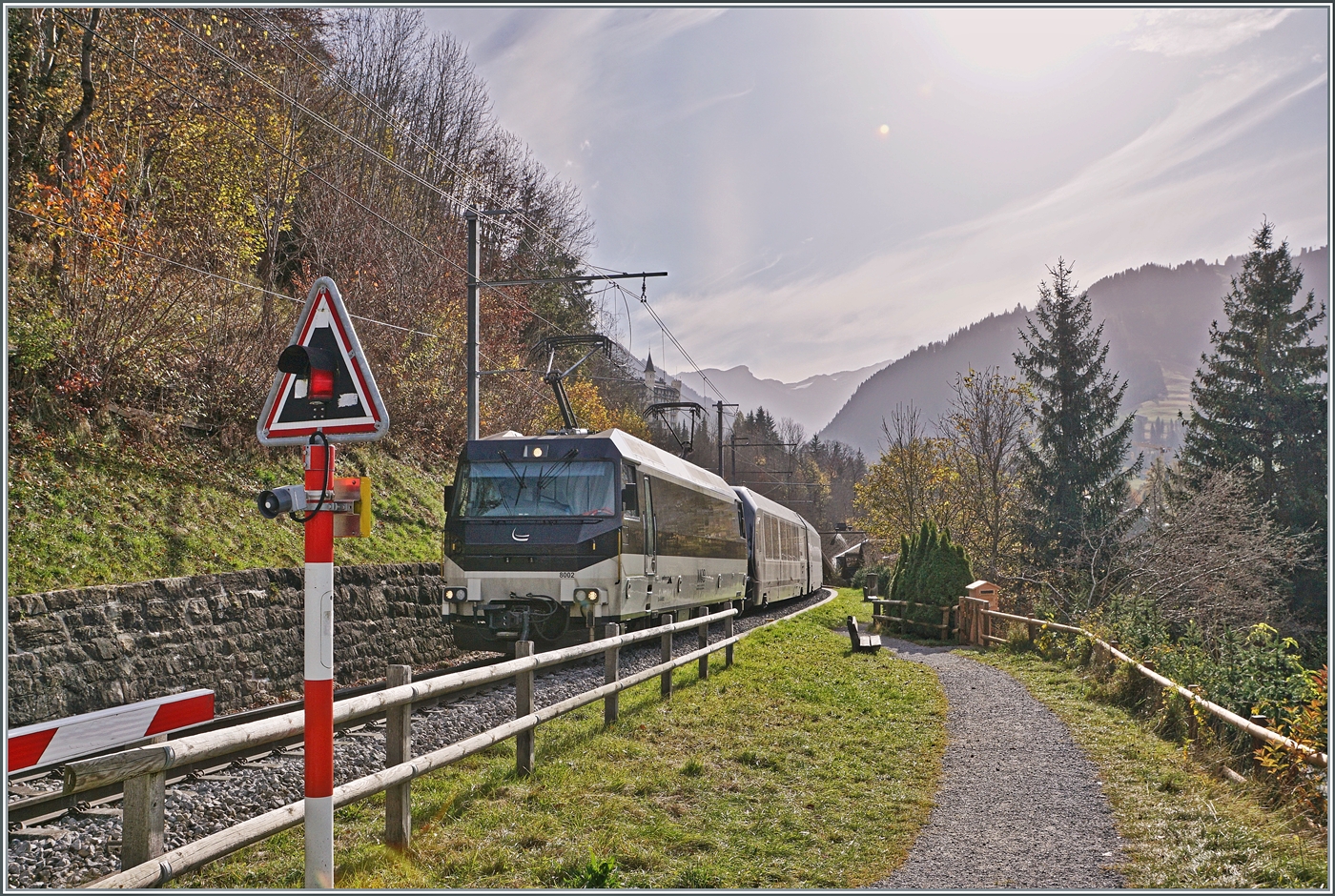 Kurz nach Gstaad erklimmt die MOB Ge 4/4 8002 mit ihrem GoldenPass Express auf der Fahrt von Montreux nach Interlaken die Steigung in Richtung Schönried und wird unmittelbar nach dieser Aufnahme über den Grubenbachviadukt fahren. 

13. Oktober 2024