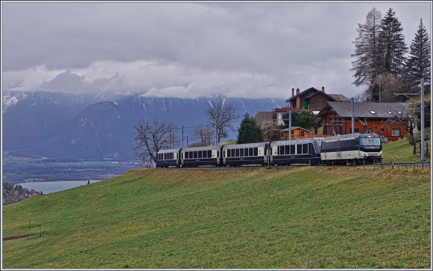 Kurz vor Les Avants ist die MOB Ge 4/4 8004 mit dem MOB/BLS GoldenPass Express GPX 4074 von Montreux nach Interlaken Ost unterwegs. Ganz links im Bild ist der Genfersee zu sehen und somit der Höhenunterschied, welcher der GPX auf den zurückgelegten zehn Kilometer ab Montreux bereits überwunden hat. 

6. Januar 2024 