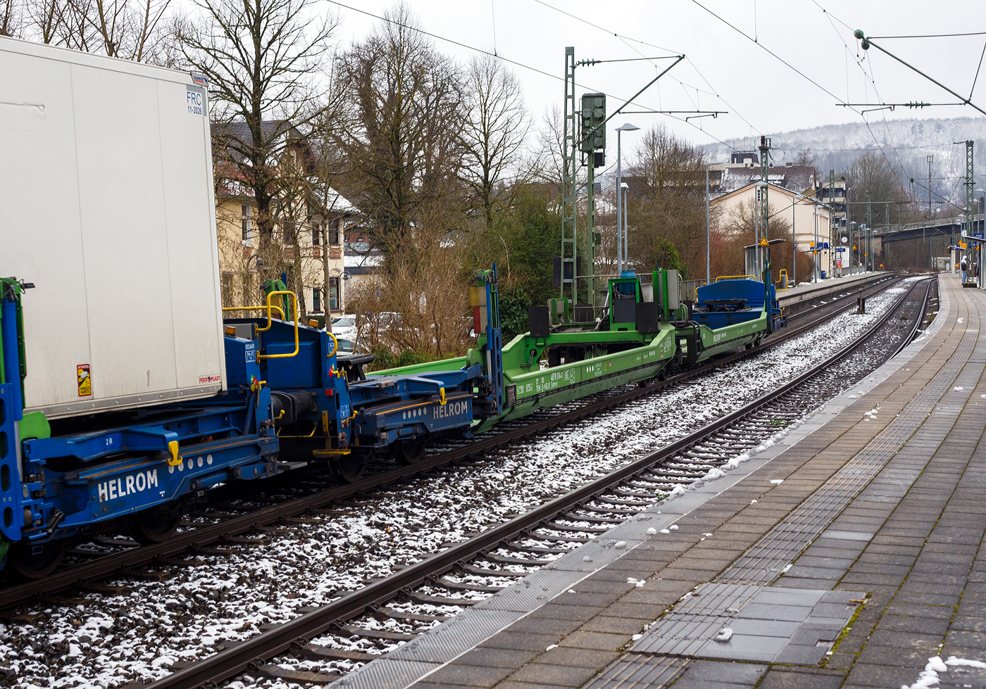 Leerer spezieller sechsachsiger Gelenk-Taschenwagen System HELROM der Gattung Sdmrs, 37 80 4878 014-2 D-HELR, der Helrom GmbH (Frankfurt am Main), am 10 Januar 2025 im Zugverband bei der Zugdurchfahrt in Kirchen/Sieg. 

Der Clou bei HELROM sind neuartige Transportwaggons, die keine teuren Kran- oder Verladeeinrichtungen brauchen. Dieses Megaswing-System ist ein spezieller Taschenwagen mit schwenkbaren Aufnahmewannen f�r Sattelauflieger. Hydraulikst�tzen dienen als Stabilisierung, wenn die Wanne nach links oder rechts ausschwenkt. Die Beladung der Wanne mit einem Sattelauflieger erfolgt r�ckw�rts. Nach Absatteln des Sattelaufliegers wird die Wanne angehoben und schwenkt wieder ein. Der Sattelauflieger wird leicht abgesenkt und mit dem Waggon fest verbunden, er ist nun auf dem Waggon sicher verstaut. Die Technik ist im Waggon verbaut.

TECHNISCHE DATEN:
Hersteller: G�k Yapi (T�rkei)
Spurweite: 1.435 mm
L�nge �ber Puffer: 34.230 mm
Drehzapfenabstand: 2 x 14.200 mm
Achsabstand im Drehgestell: 1.800 mm
Laufraddurchmesser: 920 mm (neu)
Eigengewicht: 44.900 kg 
Max. Zuladung bei Lastgrenze: 76,0 t (ab Streckenklasse D)
Max. Geschwindigkeit: 100 km/h (beladen) / 120 km/h (leer)
Kleinster befahrbarer Gleisbogen: R 75 m
Bremse: 2 x MH-GP-A (K)
Bremssohle: Cosid 810
Feststellbremse: Ja (auf ein Drehgestell)
Intern. Verwendungsf�higkeit: TEN-GE